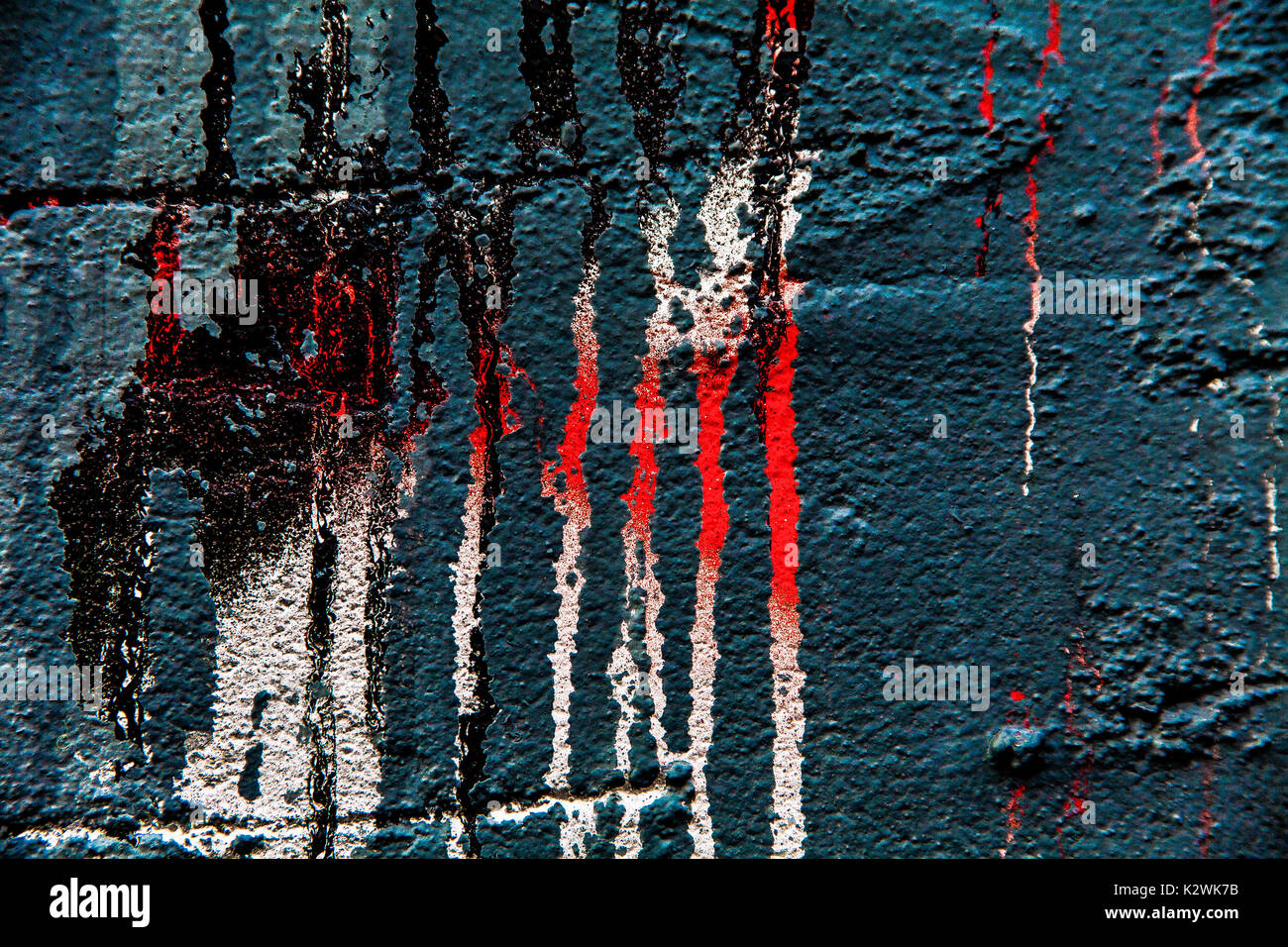 Abstract close up di vernice gocciola verso il basso grigio di un muro di mattoni Foto Stock