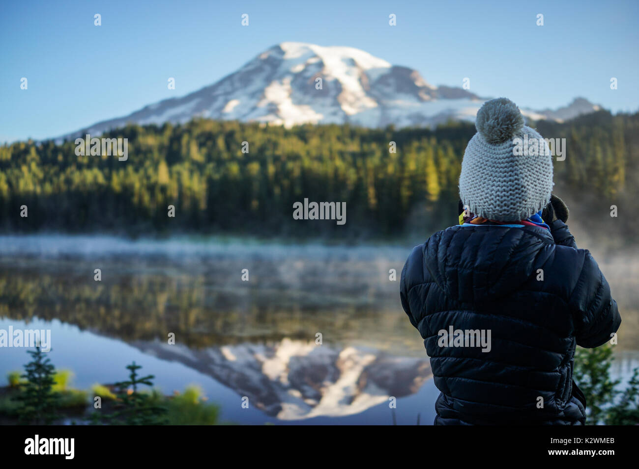 La donna fotografo è di scattare le foto della montagna e del lago alla riflessione dei laghi e il Parco Nazionale del Monte Rainier, Washington. Foto Stock