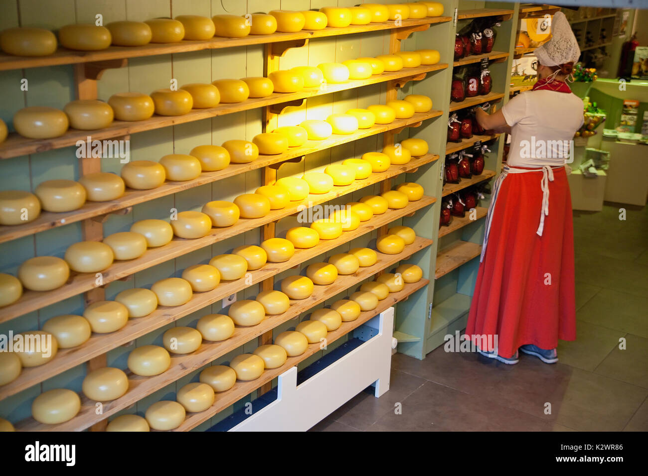 Holland, Nord, Amsterdam, negozio di formaggi lavoratore nel tradizionale costume olandese. Foto Stock