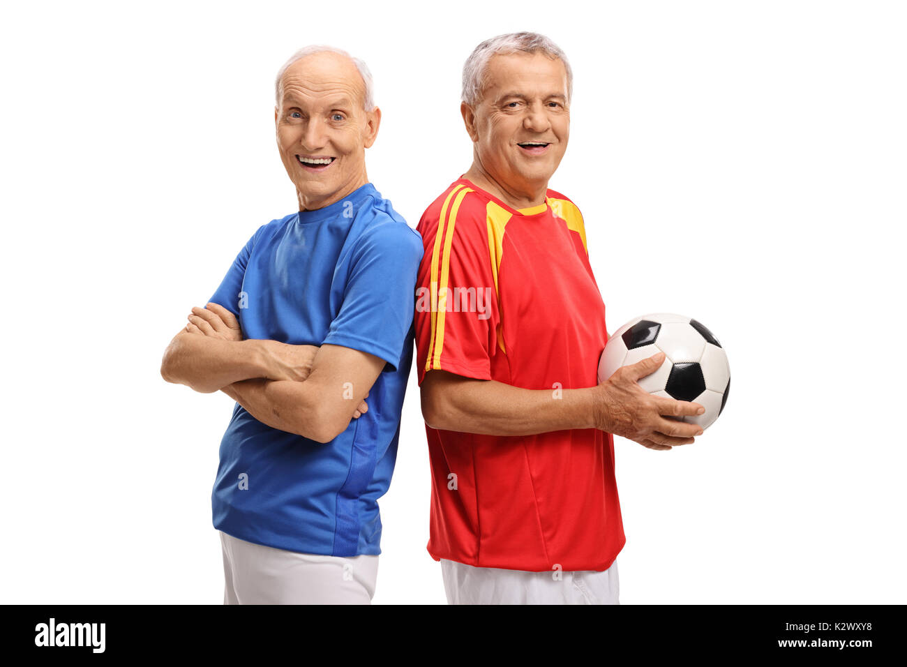 Due anziani giocatori di calcio guardando la telecamera e sorridente isolati su sfondo bianco Foto Stock