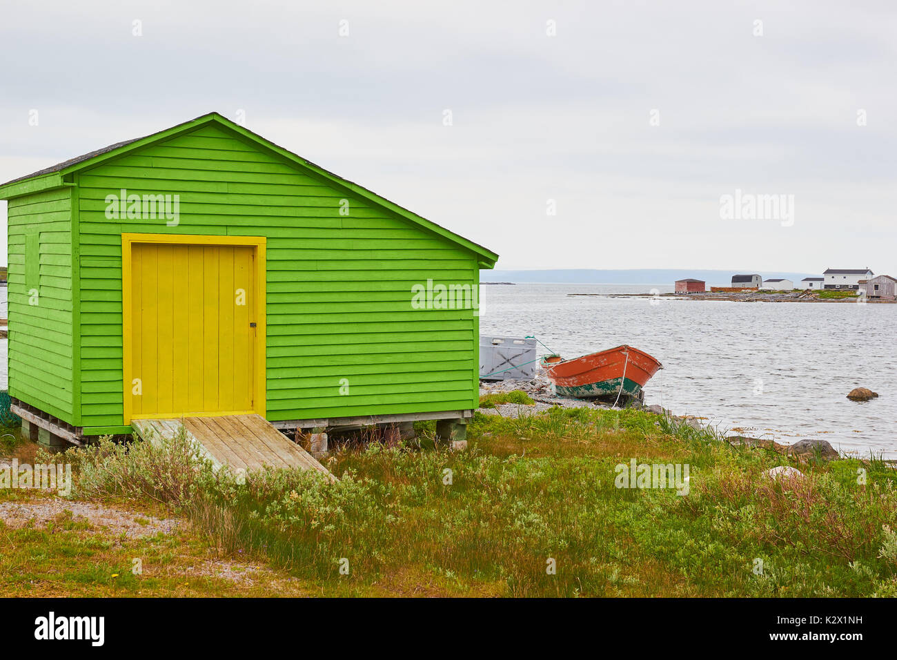 Legno verde con cabina gialla porta sulle rive dell'Oceano Atlantico, Grande Penisola Settentrionale, Terranova, Canada Foto Stock