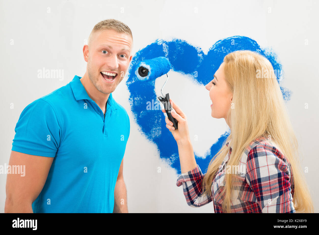 Ritratto di giovane coppia avendo divertimento mentre la pittura nella nuova casa Foto Stock