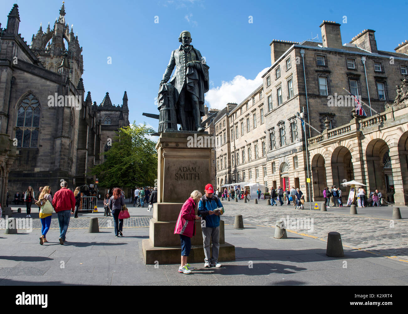 Turisti sotto la Adam Smith statua in Edinburgh Royal Mile. Foto Stock