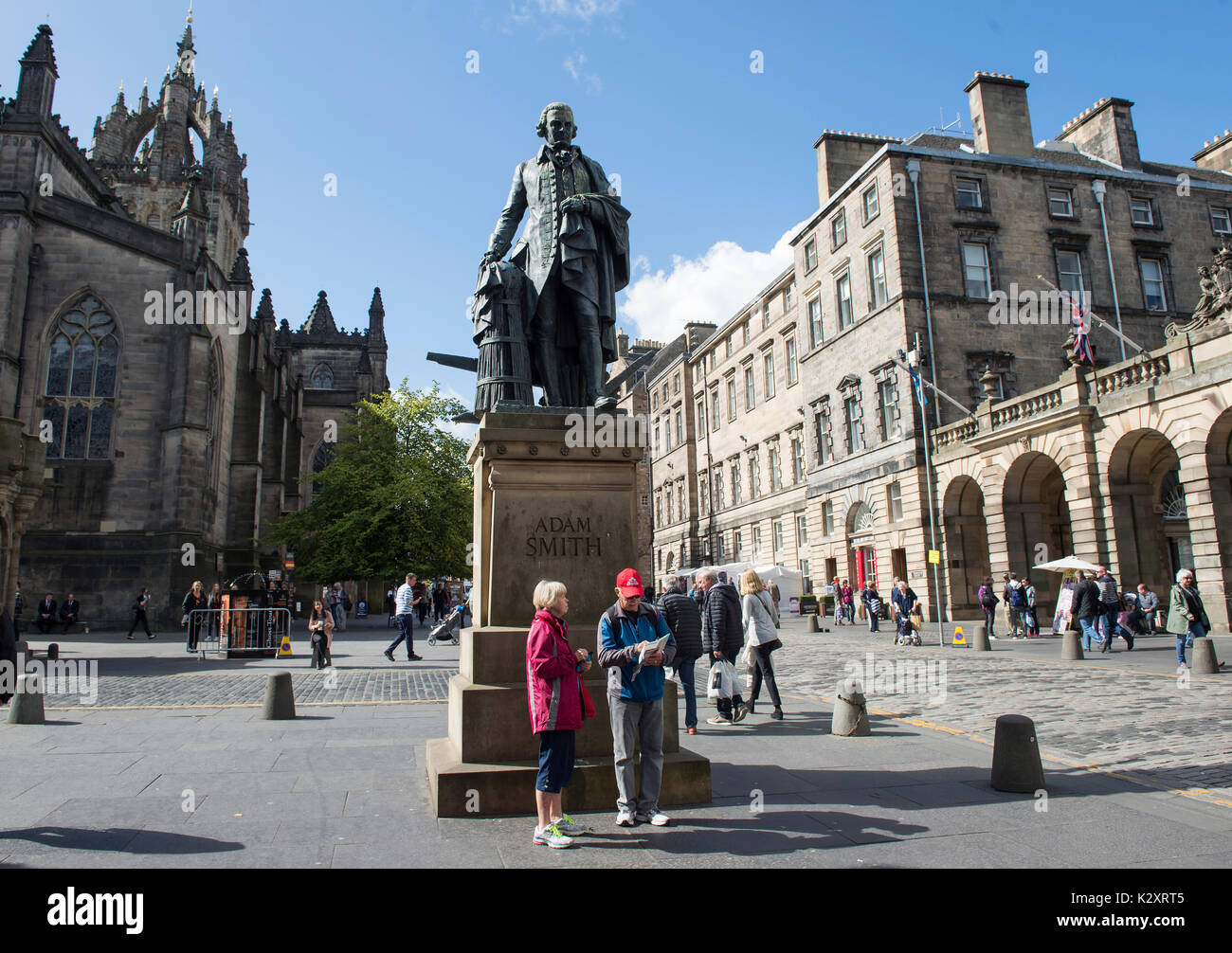 Turisti sotto la Adam Smith statua in Edinburgh Royal Mile. Foto Stock