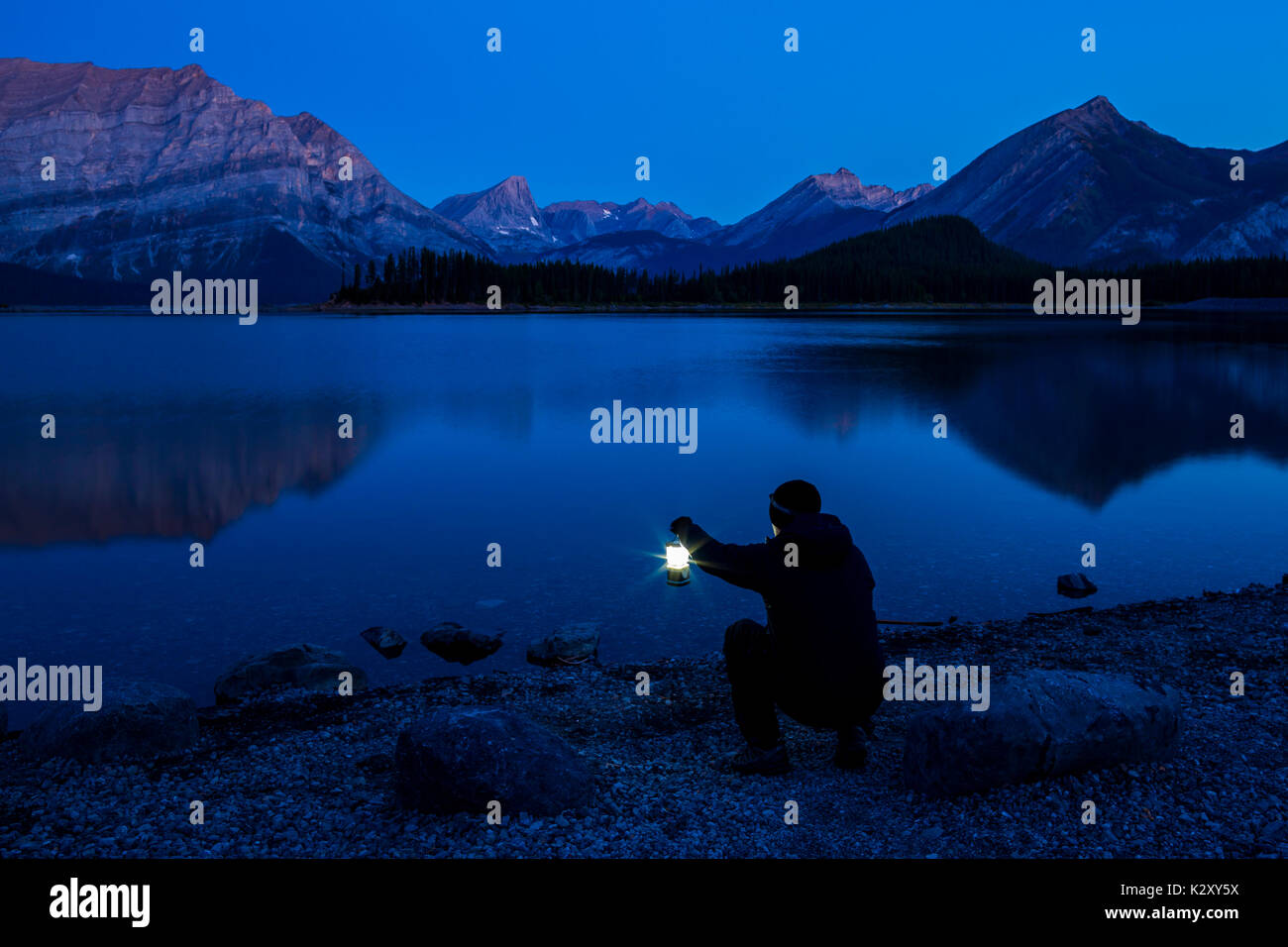 Mentre l'alpenglow cadde sulle cime che circondano l'Upper Kananaskis Lake, accesi i dintorni mentre aspettavo la mattina per arrivare. Foto Stock