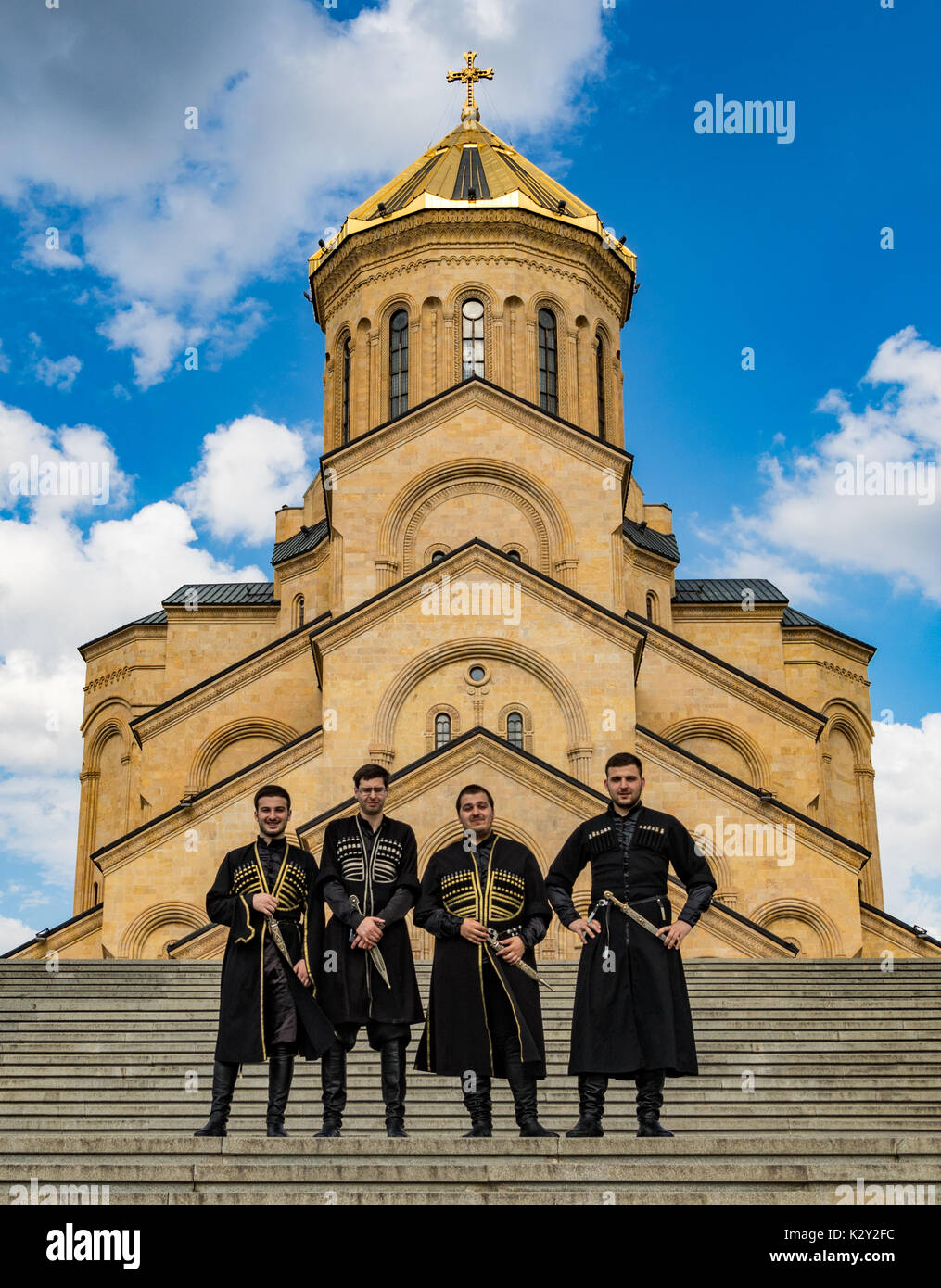 Groomsmen pongono di fronte al Georgian Metekhi chiesa ortodossa a Tbilisi, Georgia del 8 giugno 2017 Foto Stock