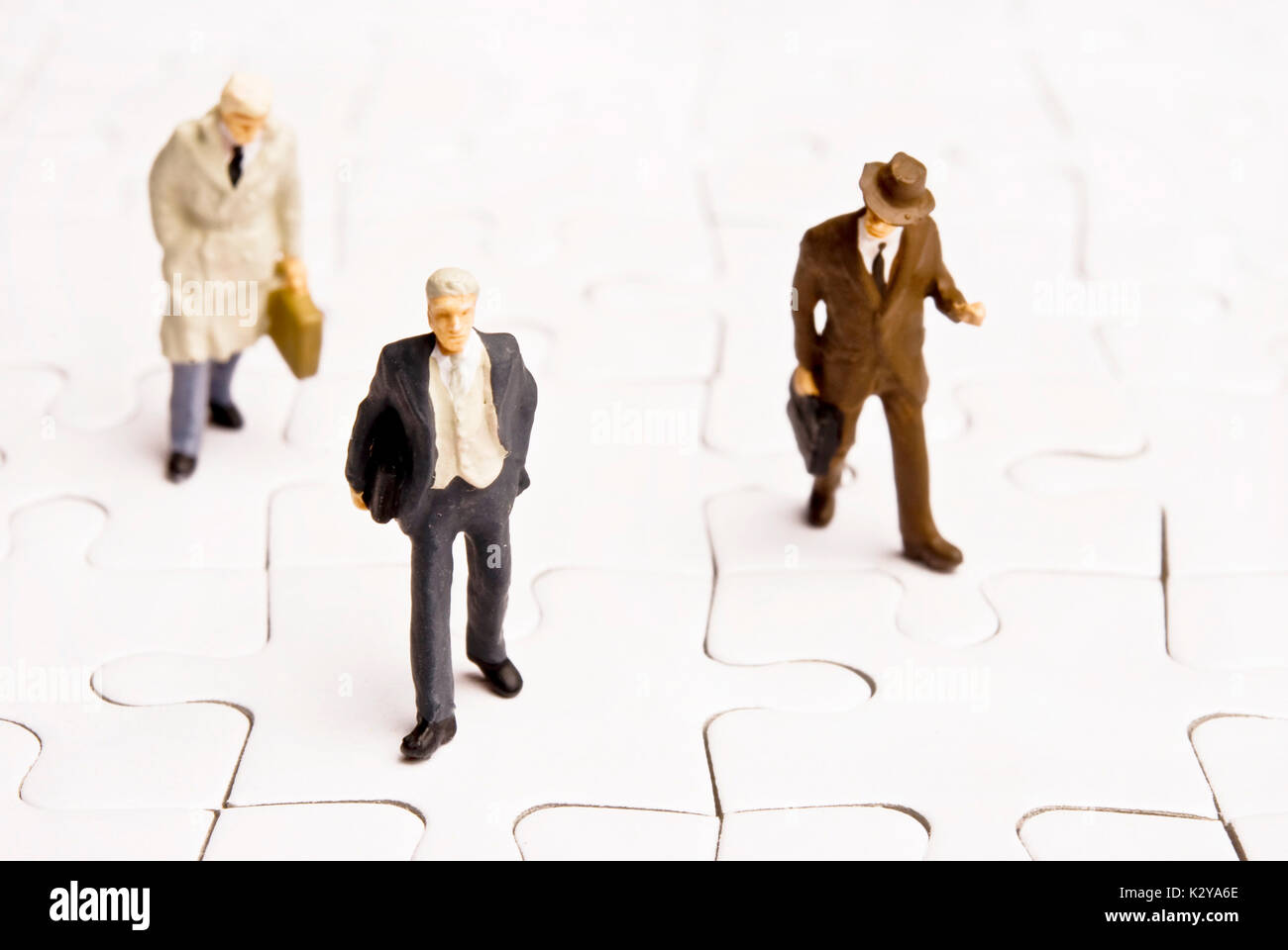 Imprenditori statuette in miniatura su di uno sbozzato puzzle Foto Stock