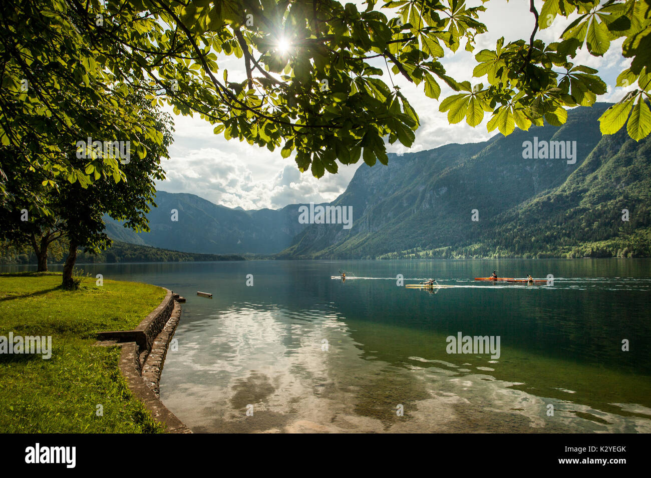 Il lago di Bohinj con canoe sulla superficie dell'acqua in estate nel pomeriggio. Foto Stock