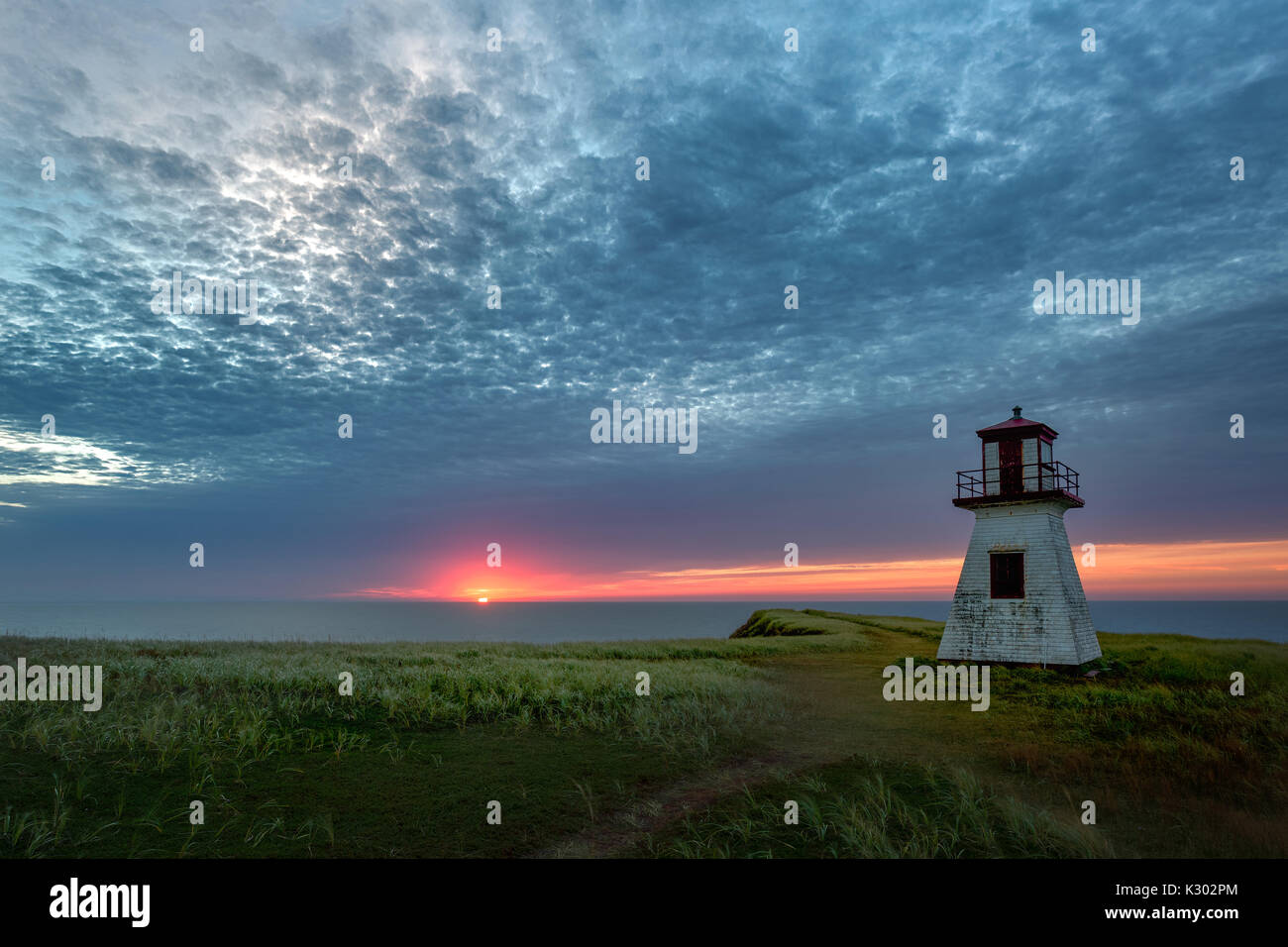 Nuvoloso Tramonto sul cappuccio Alright faro di Havre-aux-maisons sulle isole della Maddalena, Québec Foto Stock