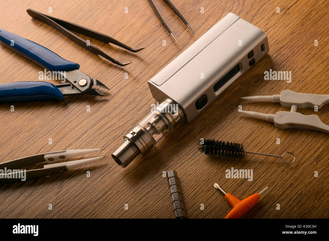 Strumenti per il dispositivo vaping, sigaretta elettronica, e-sigaretta, box  mod, accessori isolate su uno sfondo di legno. per vaping negozi Foto stock 