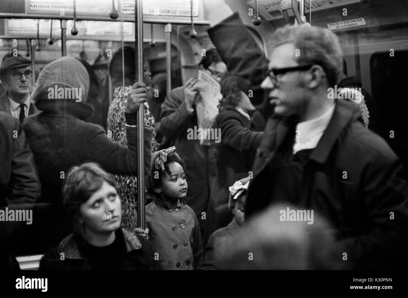 I pendolari della metropolitana di Londra due bambini neri in metropolitana affollata madre dietro di loro. Inghilterra 1970. 1970 UK HOMER SYKES Foto Stock