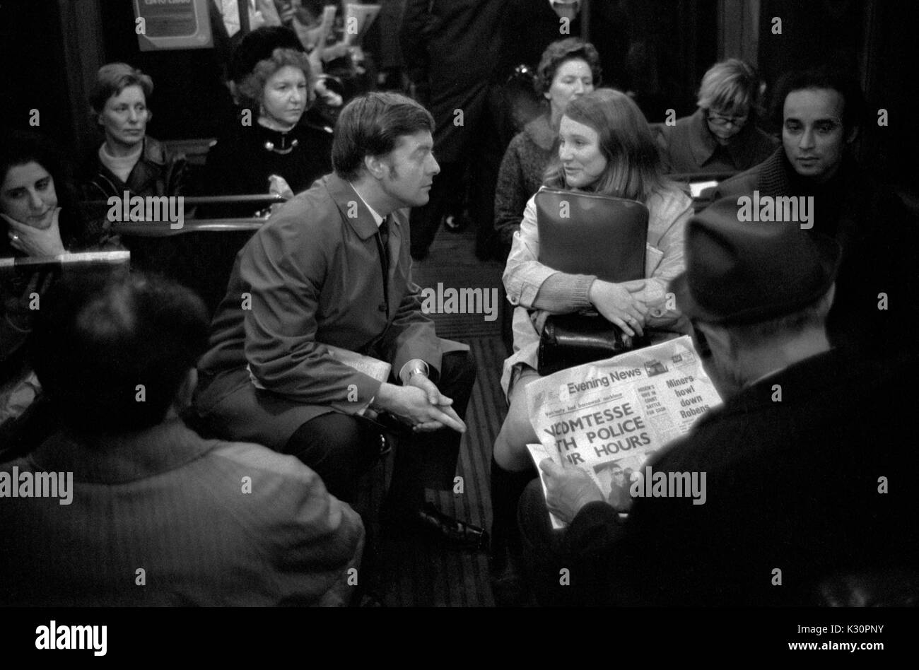 Metropolitana britannica degli anni '1970 di Londra, treno sotterraneo due pendolari su treni affollati durante l'ora di punta. Uomo che legge il giornale Evening News, tutti tornano a casa dopo il lavoro. Trasporto Londra 1970 Inghilterra HOMER SYKES Foto Stock