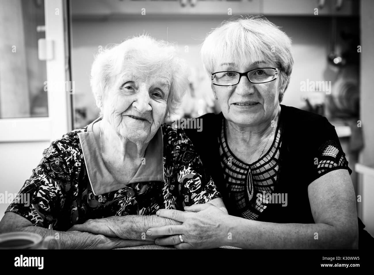 Donna anziana in casa con la sua figlia adulta. Foto in bianco e nero. Foto Stock