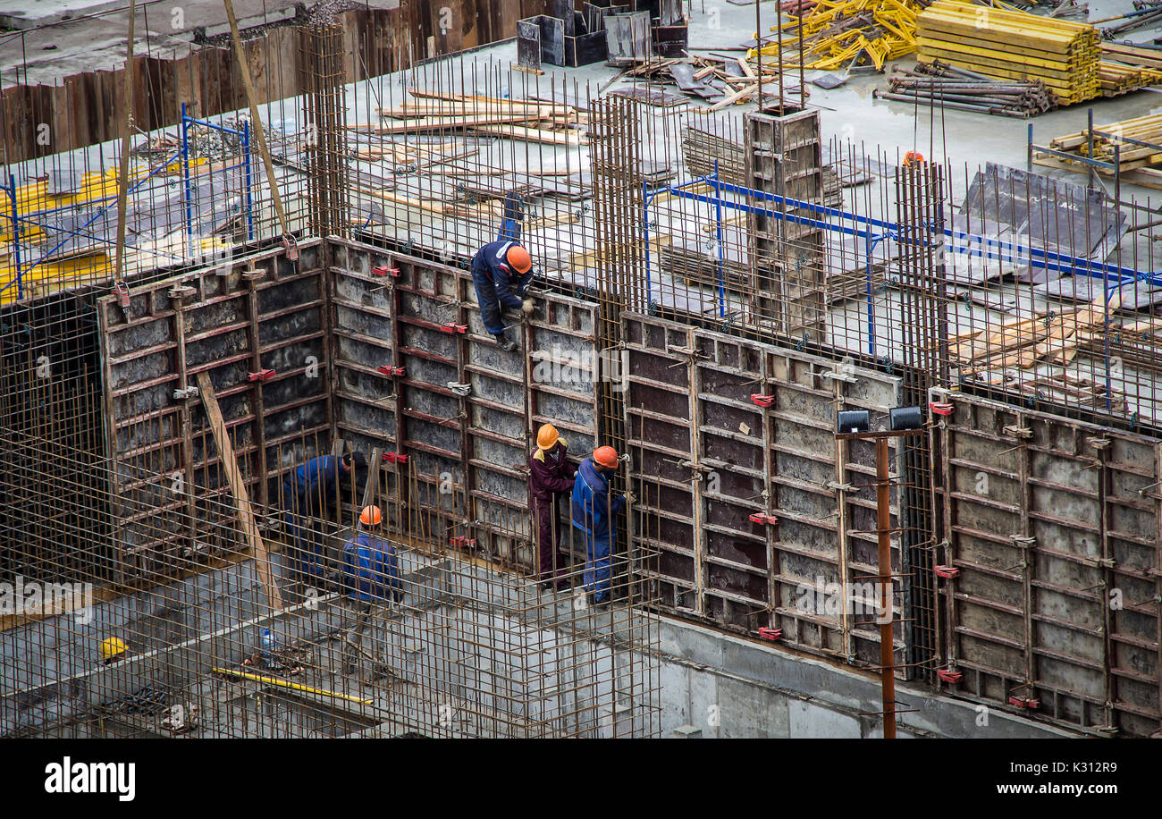 I lavoratori industriali e costruttori di compressori hardhat in uniforme versare cemento e mount Foto Stock