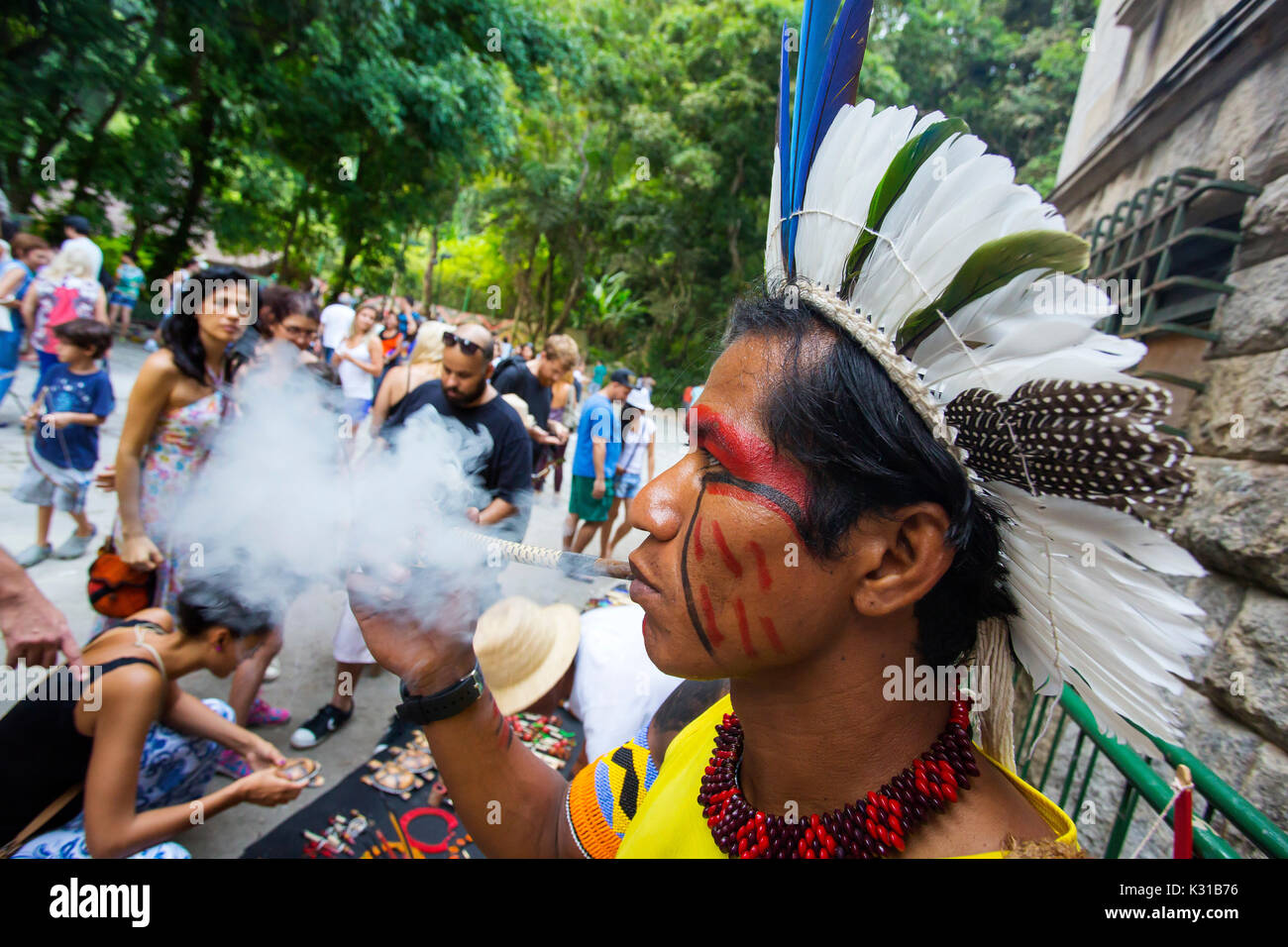 Brasiliano tradizionale indiano con faccia dipinta fumare la pipa al Parque Laje nel comemoration dell'indiano del giorno, Rio de Janeiro, Brasile Foto Stock