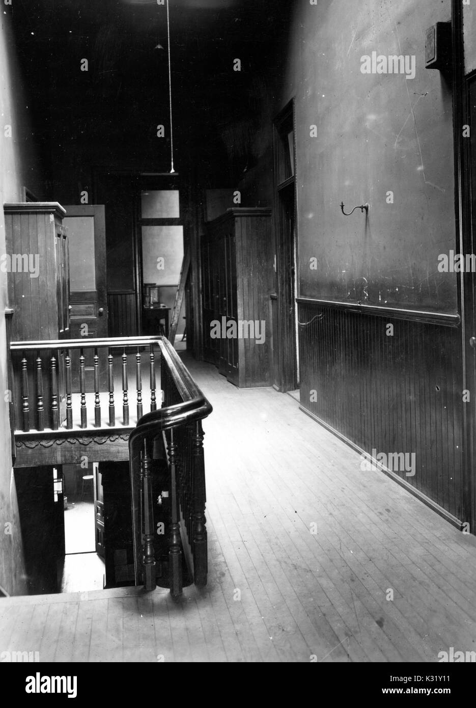 Fotografia in scala di grigi del terzo piano corridoio all'interno dell'edificio di chimica presso Old Campus della Johns Hopkins University, mostrando una ringhiera in legno e le porte che conducono a laboratori e aule, Baltimore, Marylabnd, Baltimore, Maryland, 1918. Foto Stock