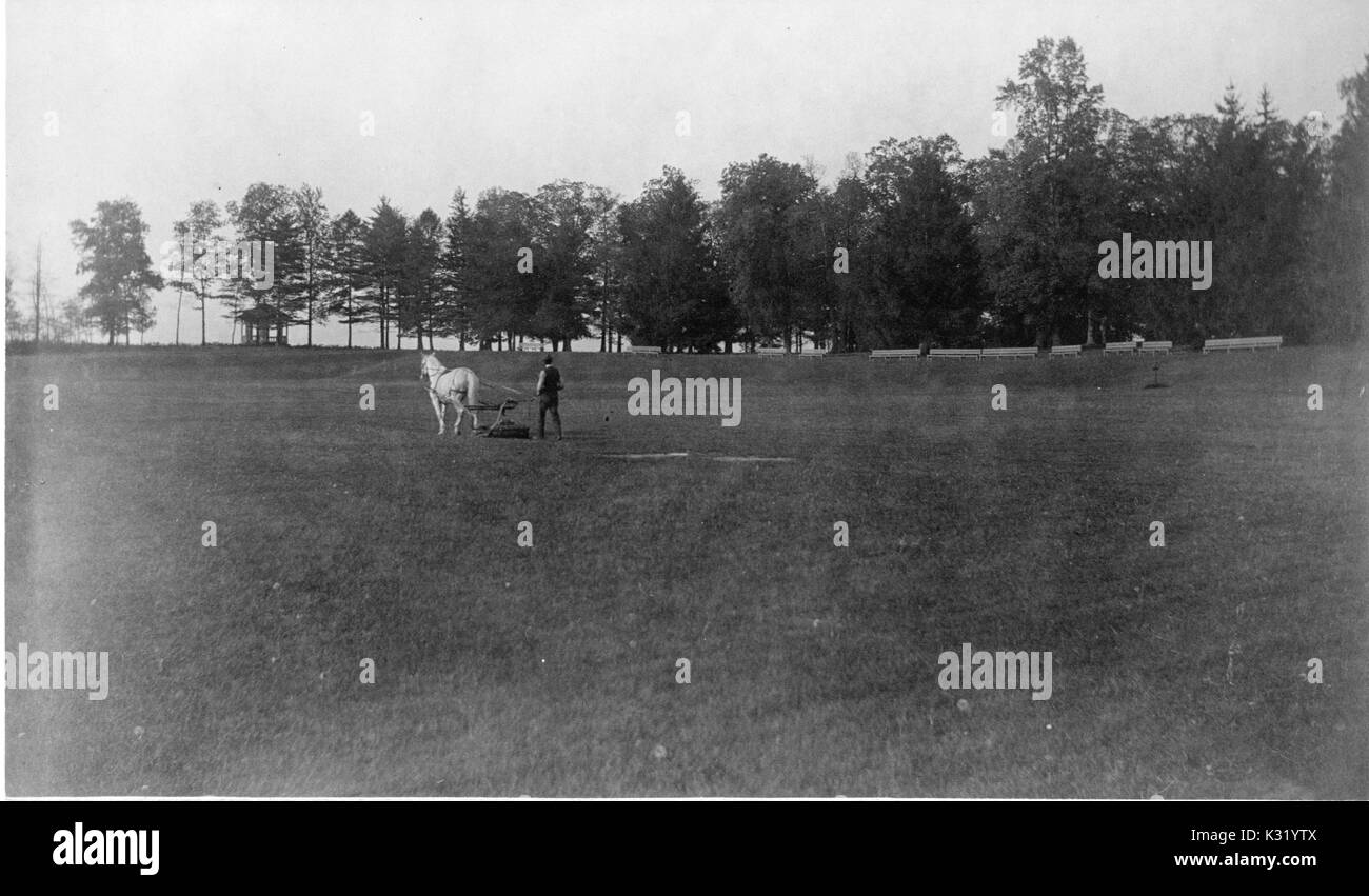 Tonalità seppia fotografia di un uomo a cavallo aratura in distanza lungo i giardini di Clifton Mansion, costruito alla fine del XVIII secolo come una storia di due agriturismo federale ma in seguito si è espanso in un epoca vittoriana villa italiana, di proprietà di filantropo Johns Hopkins e successivamente acquistato dalla città di Baltimora, Baltimore, Maryland, 1895. Foto Stock