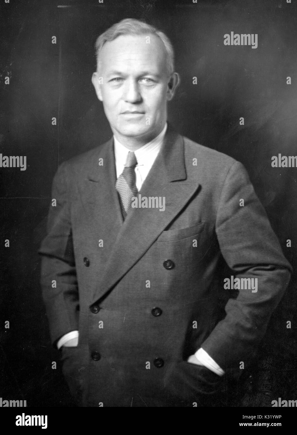 Seppia fotografia ritratto dalla vita in su di Thomas Francis pettinatore, Jr, designer e docente di ingegneria civile presso la Johns Hopkins University, in piedi con le mani in tasca, indossando il doppio petto blazer e cravatta, Baltimore, Maryland, 1940. Foto Stock Seppia fotografia ritratto dalla vita in su di Thomas Francis pettinatore, Jr, designer e docente di ingegneria civile presso la Johns Hopkins University, in piedi con le mani in tasca, indossando il doppio petto blazer e cravatta, Baltimore, Maryland, 1940. Foto Stock