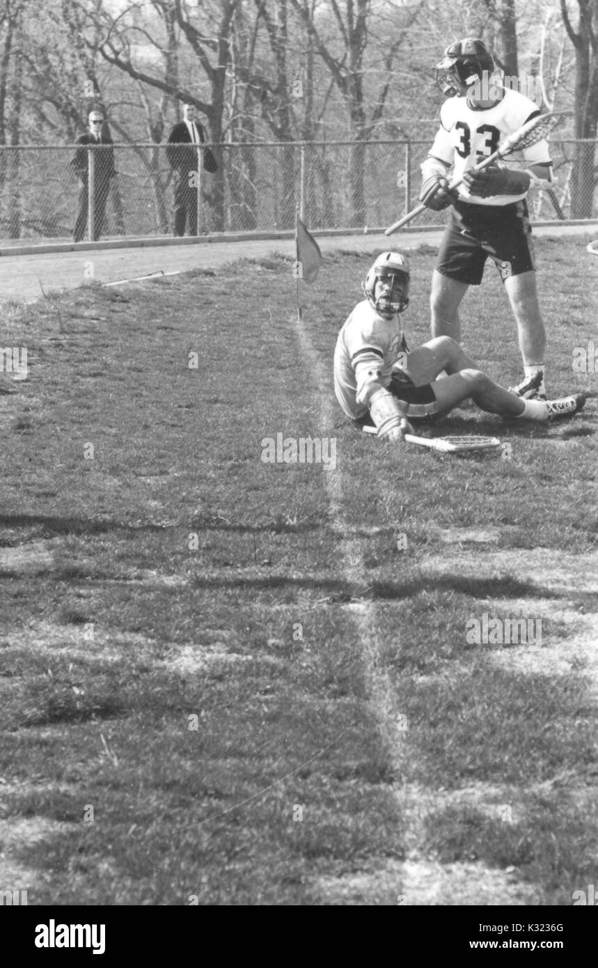 I giocatori su un campo, uno dei quali è seduto sull'erba, durante una divisione N.C.A.A. uno lacrosse gioco, in cui un team è stato Johns Hopkins University, 1975. Foto Stock