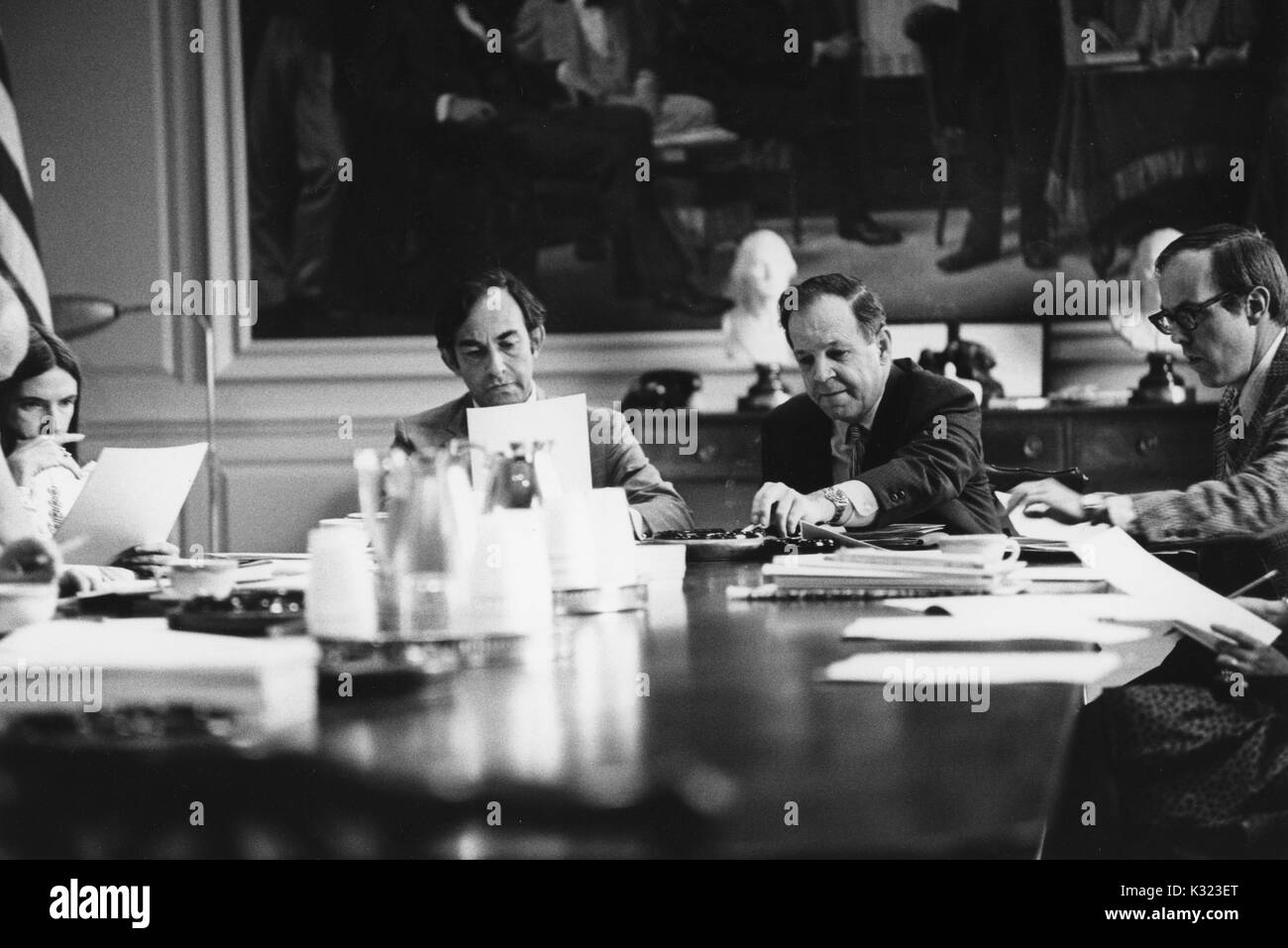 I membri di facoltà e administration presso la Johns Hopkins University e Goucher College si riuniscono per un incontro a un lungo tavolo da conferenza con le carte, tazze da caffè, e portacenere sparse su tutta la parte superiore, Baltimore, Maryland, 1975. Foto Stock