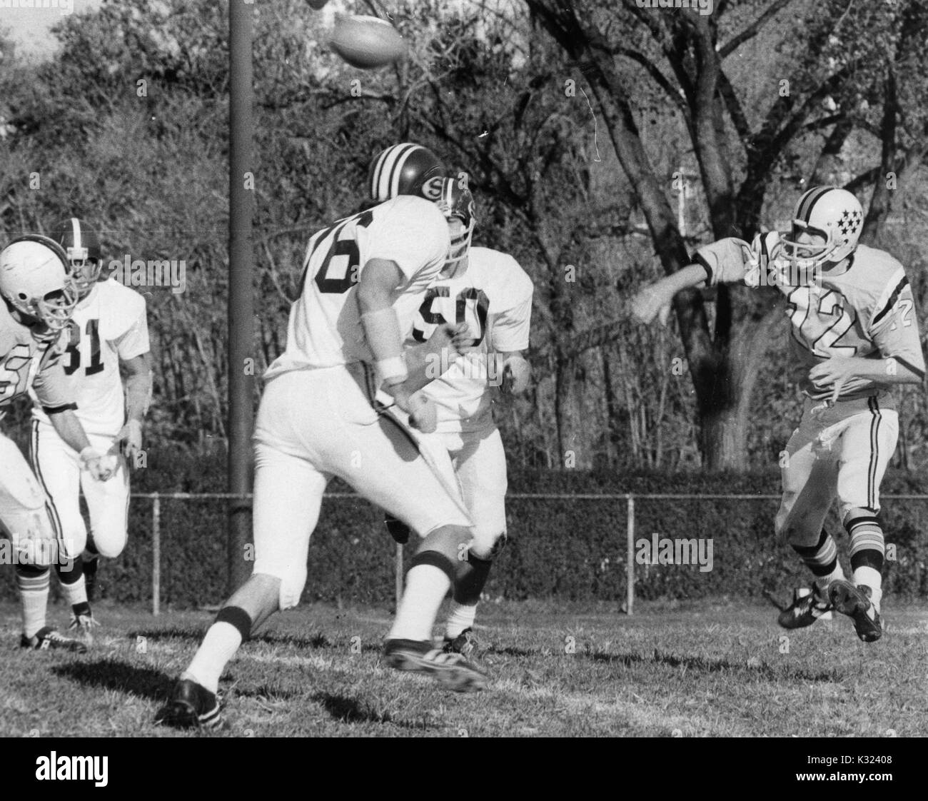 La Johns Hopkins University quarterback getta il calcio come due giocatori della squadra avversaria avvicinarsi a lui per affrontare alla Johns Hopkins University, Baltimora, Maryland, 1980. Foto Stock