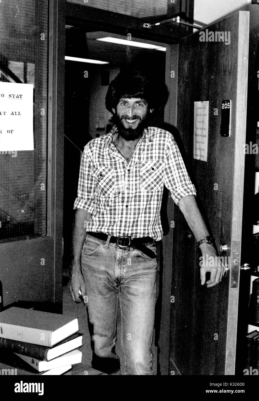 Declan De Paor, geologo e geophysicist presso la Johns Hopkins University, sorride mentre indossano jeans all'interno di una porta di Olin Hall, la Terra e Scienze Planetarie edificio del campus, Baltimore, Maryland, marzo 1985. Foto Stock