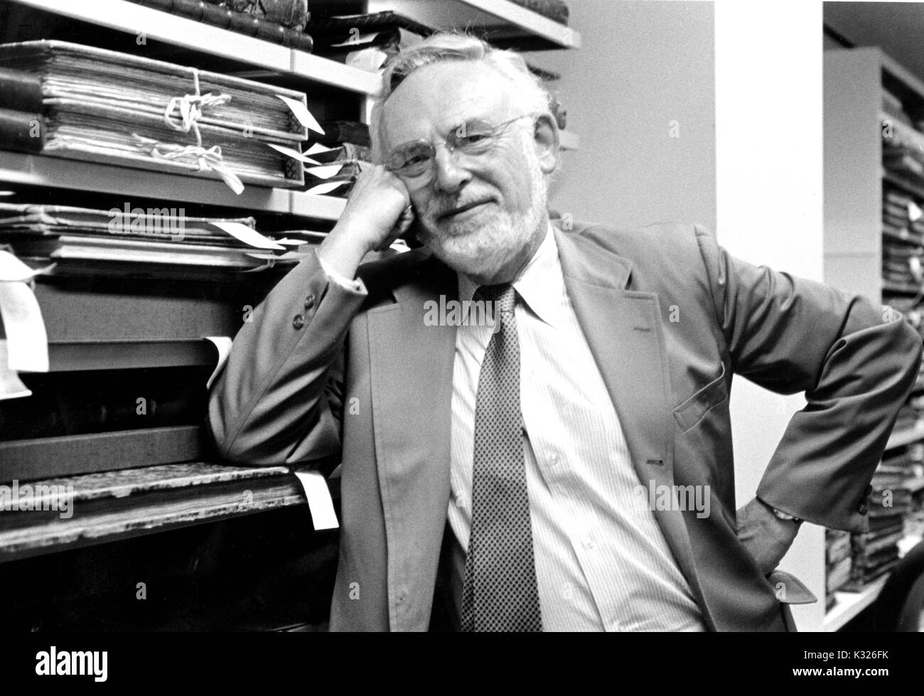 Jerome Melvin Edelstein, bibliographer e studioso in molti campi delle scienze umanistiche, appoggia contro i ripiani materiali di tenuta da una libreria di collezioni speciali, 1990. Foto Stock