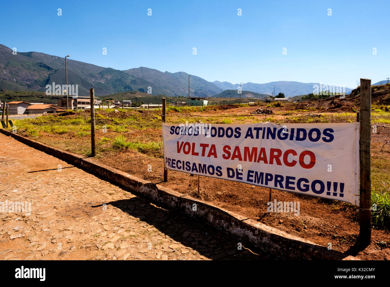 Un banner sul ciglio della strada un appello per il ritorno di Samarco Mineração al Bento Rodrigues, Mariana regione a causa della mancanza di posti di lavoro, Minas Gerais, Brasile. Foto Stock