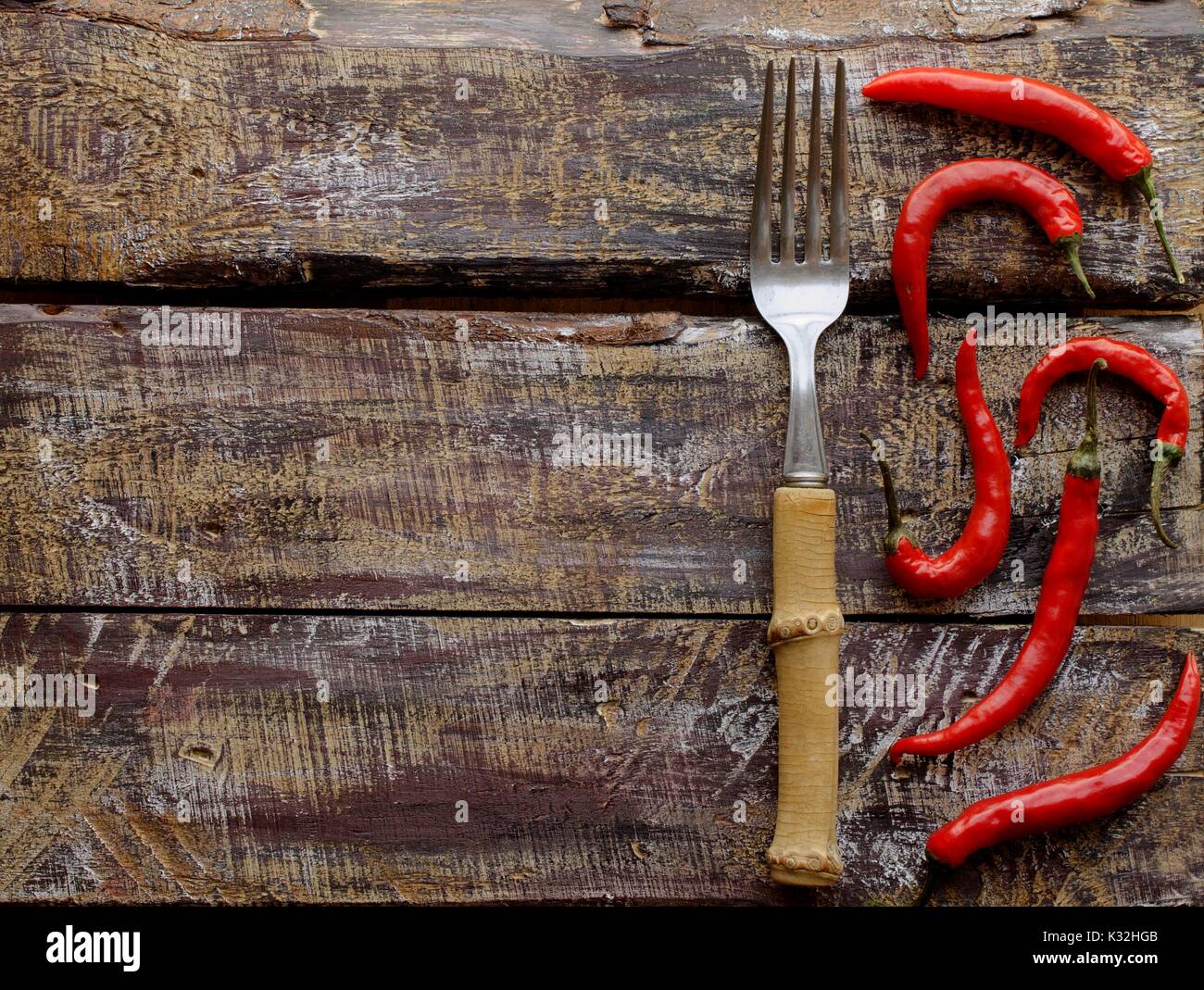 Peperoncino rosso su una tavola di legno con una forcella, concetto, il fuoco selettivo, vista dall'alto Foto Stock