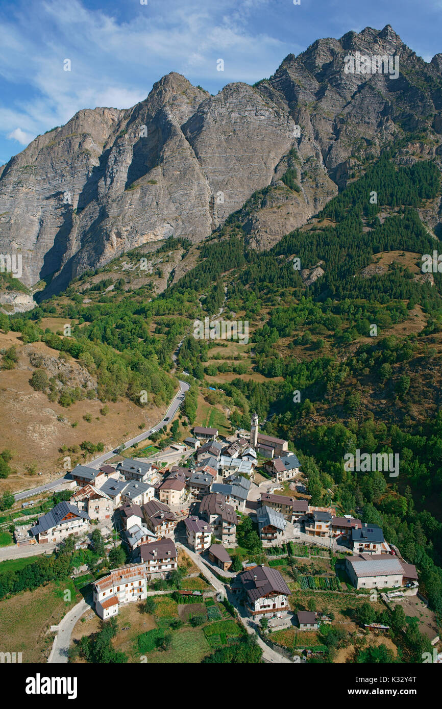 VISTA AEREA. Piccolo villaggio remoto ai piedi di una massiccia scogliera. Pontebernardo, Stura di Demonte, Provincia di Cuneo, Piemonte, Italia. Foto Stock