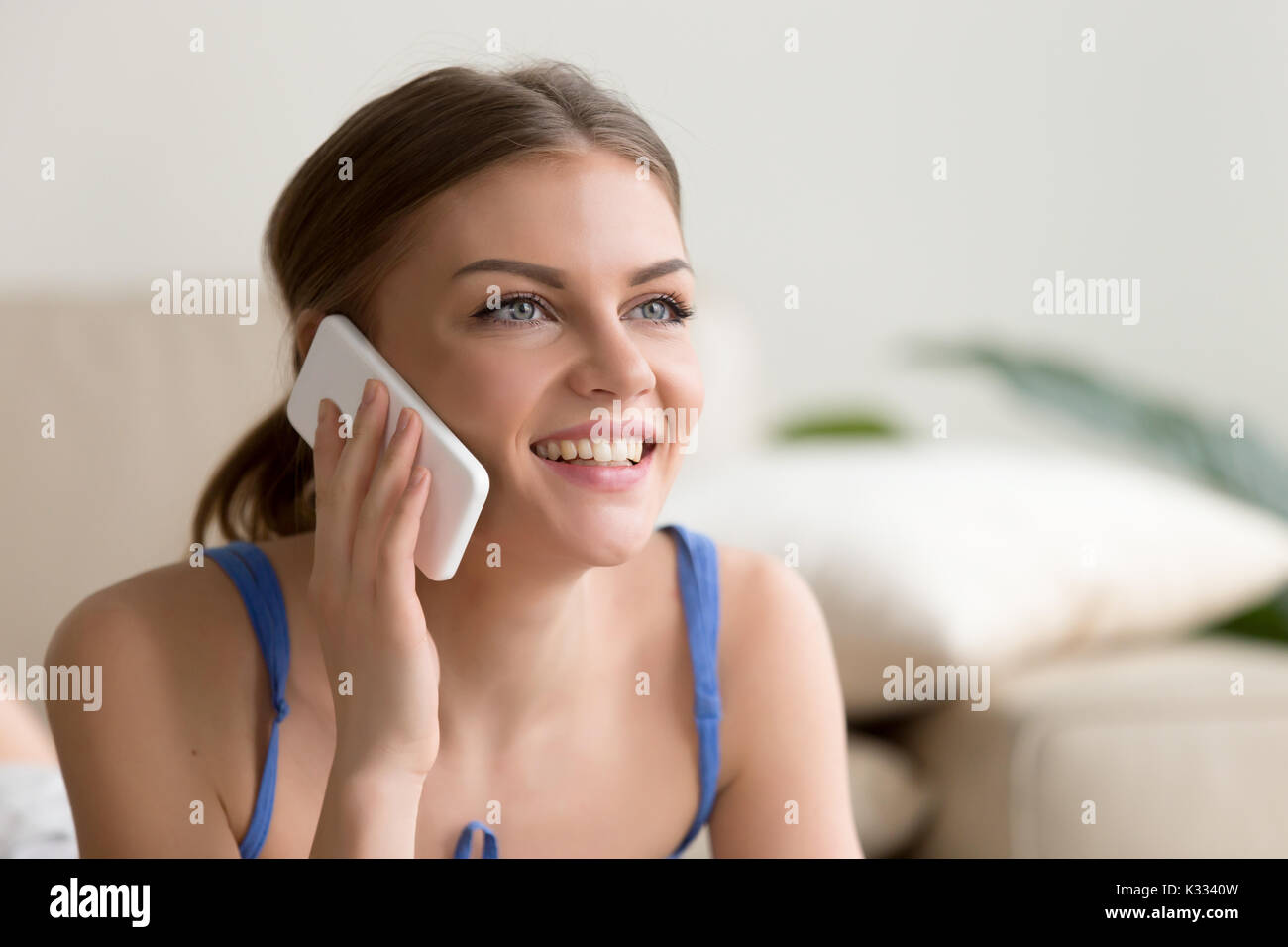 Donna felice di parlare al cellulare a casa Foto Stock