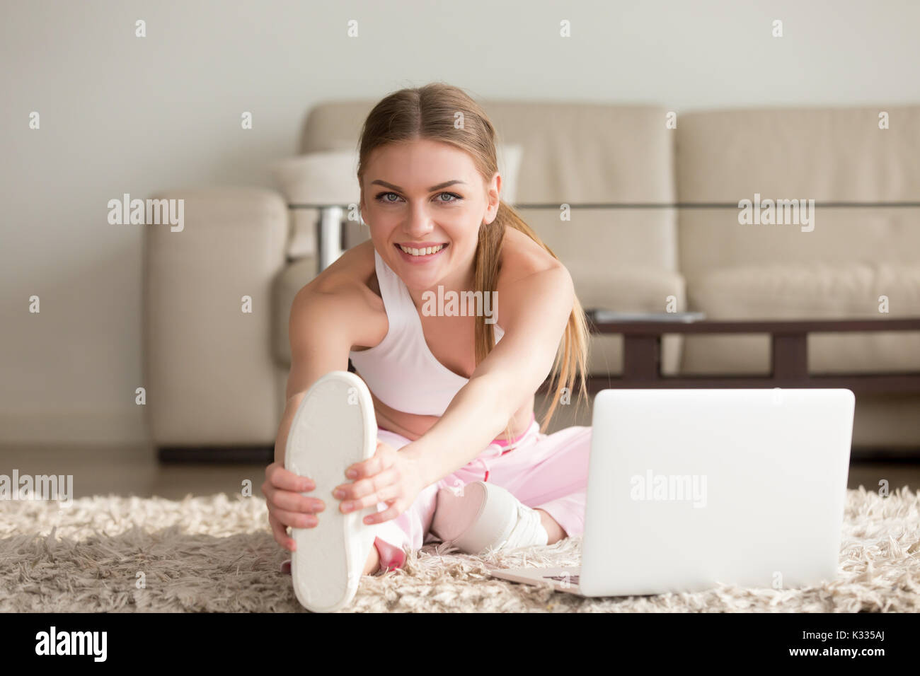 Donna facendo stretching esercizi di fitness in casa Foto Stock