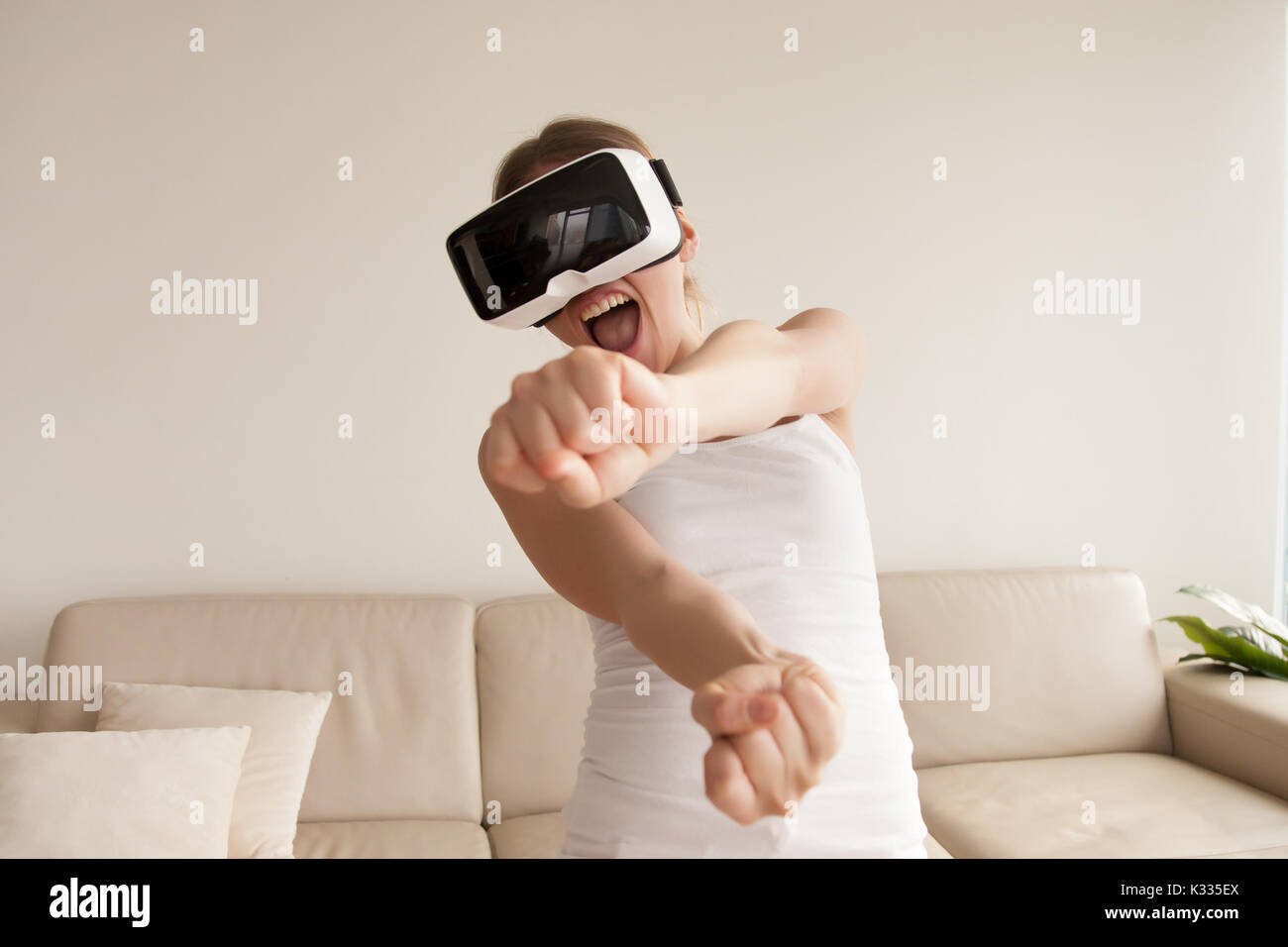 Donna in occhiali VR godendo di videogame 3D a casa Foto Stock