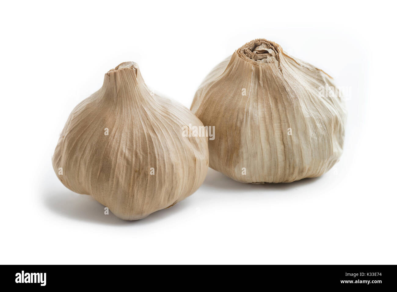 Coppia di tutta la lampadina di casa nero fermentato aglio. Ultima meraviglia cibo ,ricco di antiossidanti, vitamine e minerali. Su un isolato sfondo bianco Foto Stock