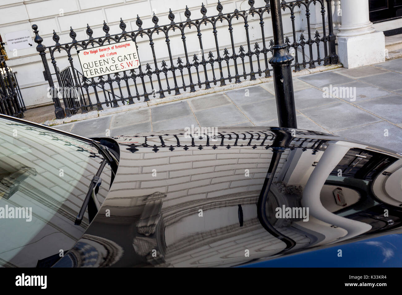 Ringhiere e una parete di ambasciata riflessa nel cofano lucidato (cofano) di un diplomatico auto BMW in Queen's Gate Terrazza SW7, il 31 agosto 2017, nel quartiere londinese di Kensington e Chelsea, Inghilterra. Foto Stock