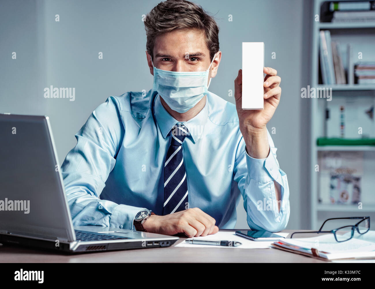Lavoratore sano in ufficio azienda white box o medicina. Foto di un uomo che indossa la maschera di protezione contro le malattie infettive e l'influenza. Business e hea Foto Stock