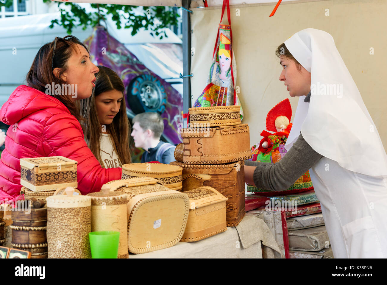 Kristiansand, Norvegia - 16 agosto 2017: documentario di viaggio della vita quotidiana nella città. Donna vendita di corteccia di betulla le caselle in strada del mercato. Qui a parlare Foto Stock