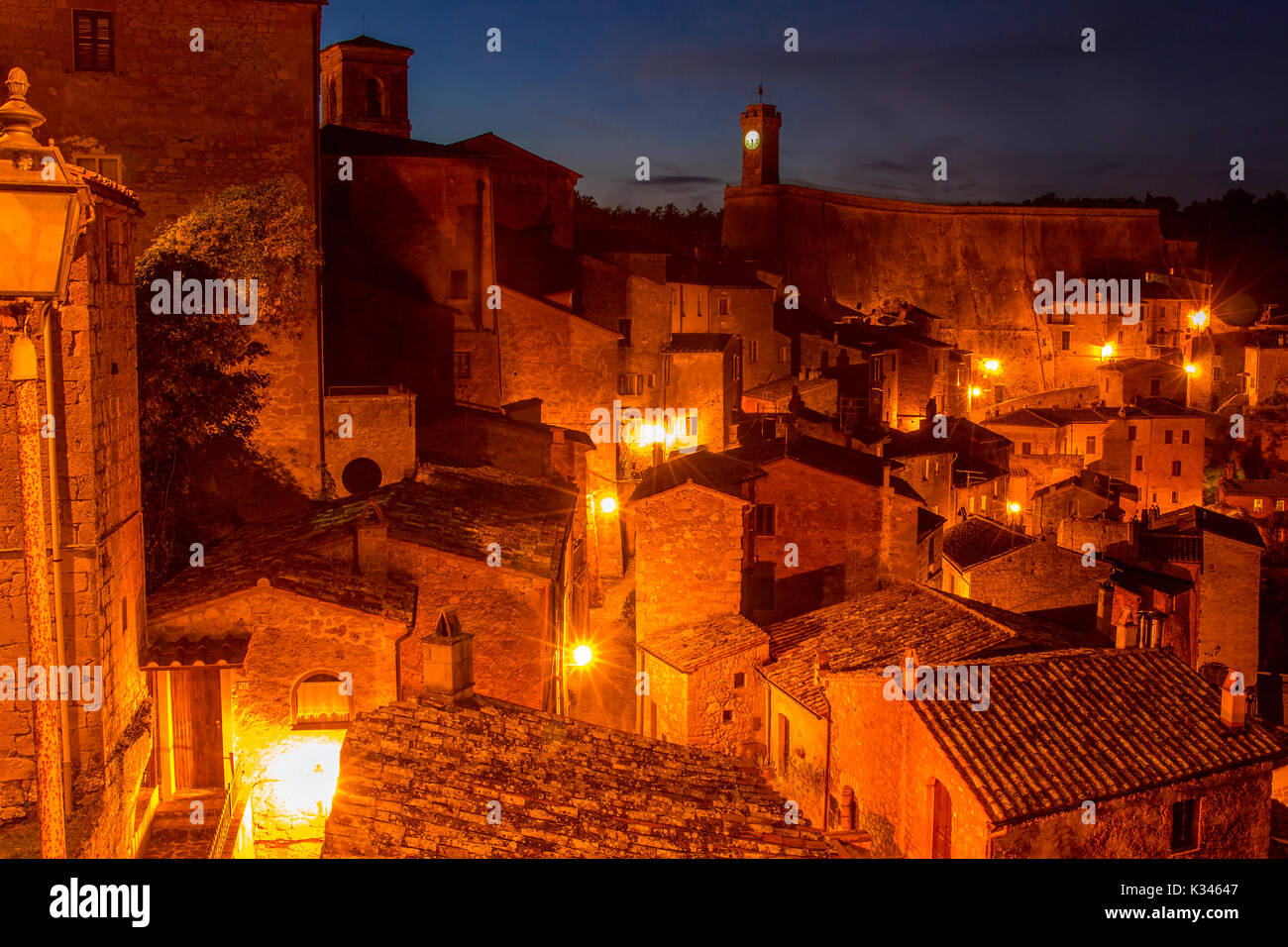 Vecchia città italiana di Sorano di notte. Le luci di strada illumina i tetti delle case antiche Foto Stock