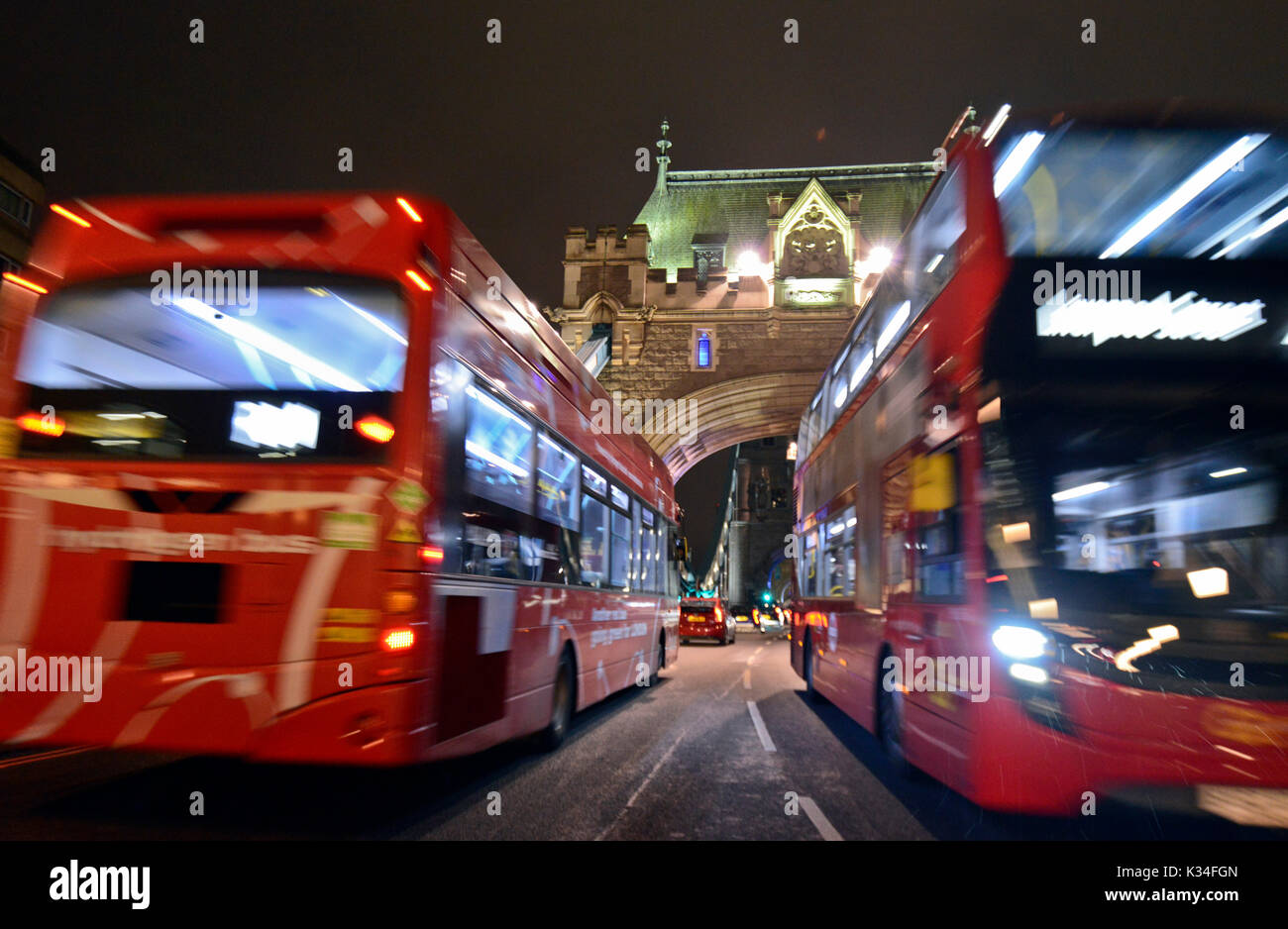 Autobus rossi attraversando Torre Birdge di notte, Londra Foto Stock