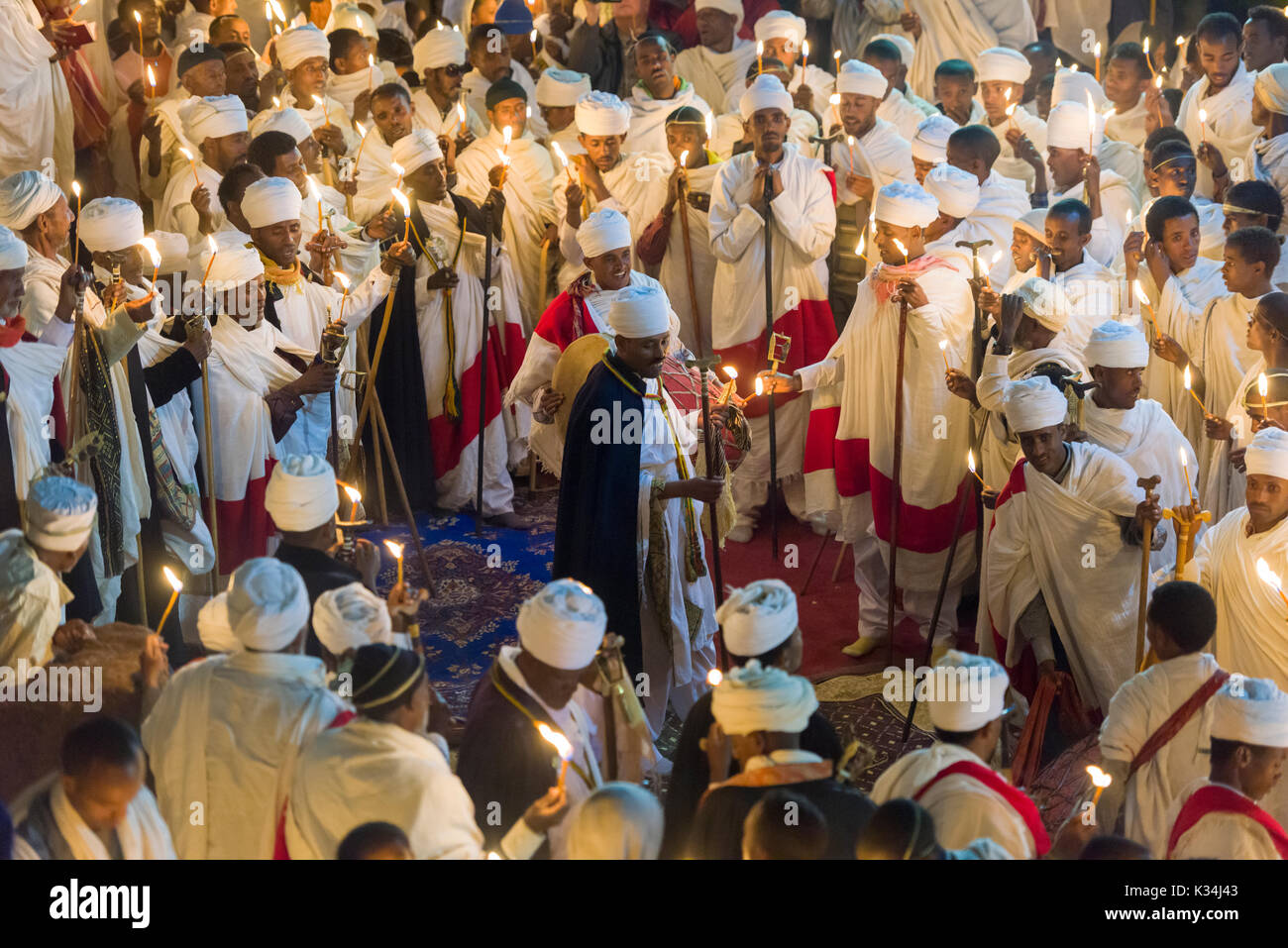 I sacerdoti canti preghiere a lume di candela nel cortile di Bet Medhane Alem chiesa, durante la preghiera sulla chiesa ortodossa etiope Sabato di Pasqua, Lalibela, Etiopia Foto Stock