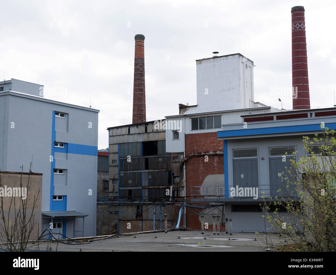 Edificio in fabbrica con serbatoio per l'acqua. La luce diurna, cielo nuvoloso, il sito di chimici da 70s a 90s. Industria chimica per i prodotti farmaceutici. Foto Stock