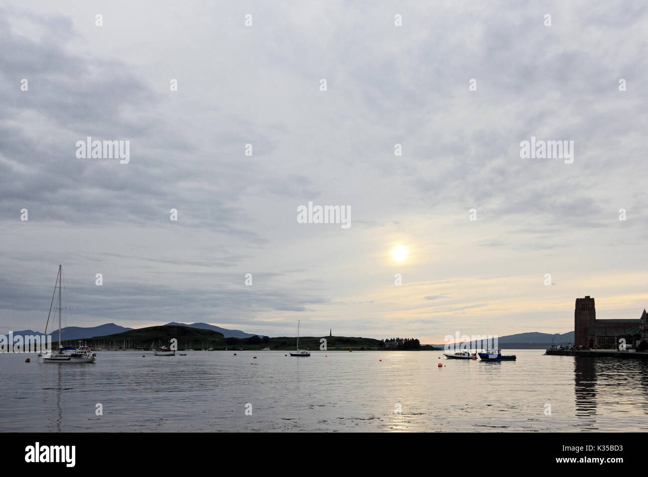 Nuvoloso Tramonto sulla Baia di Oban, Scozia Foto Stock
