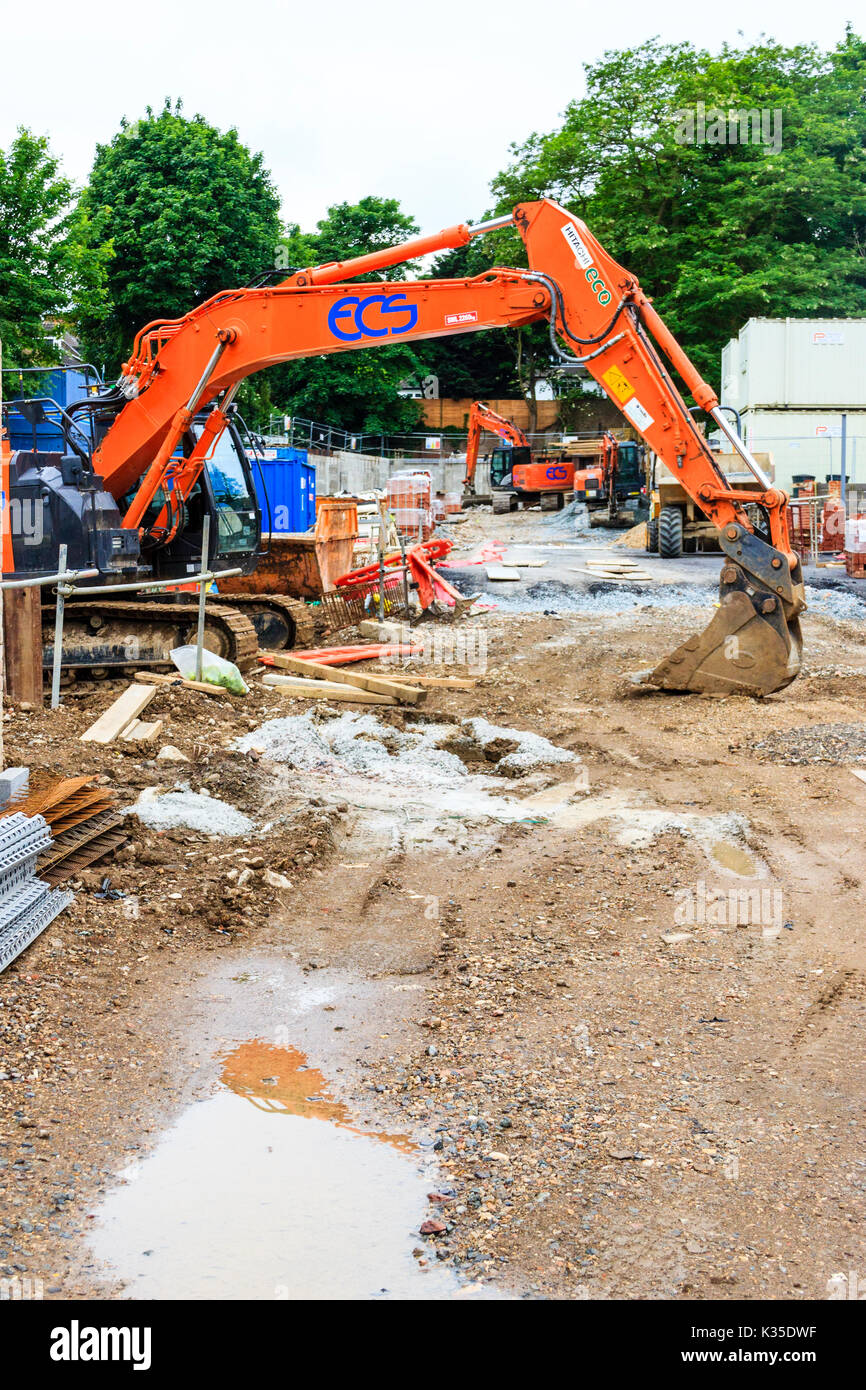 Macchina movimento terra arancione, riassetto della vecchia scuola Ashmount sito, Islington, a nord di Londra, Regno Unito Foto Stock