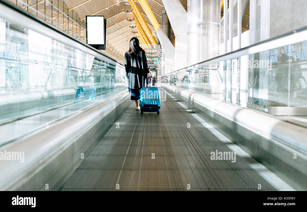 Donna che cammina in aeroporto Foto Stock