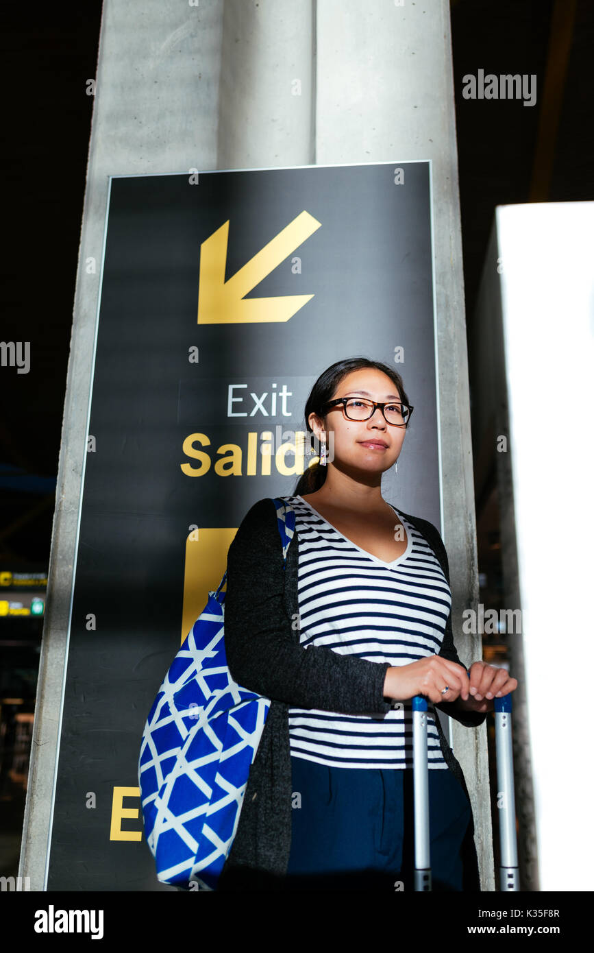 Donna asiatica in un'area in ombra in aeroporto Foto Stock