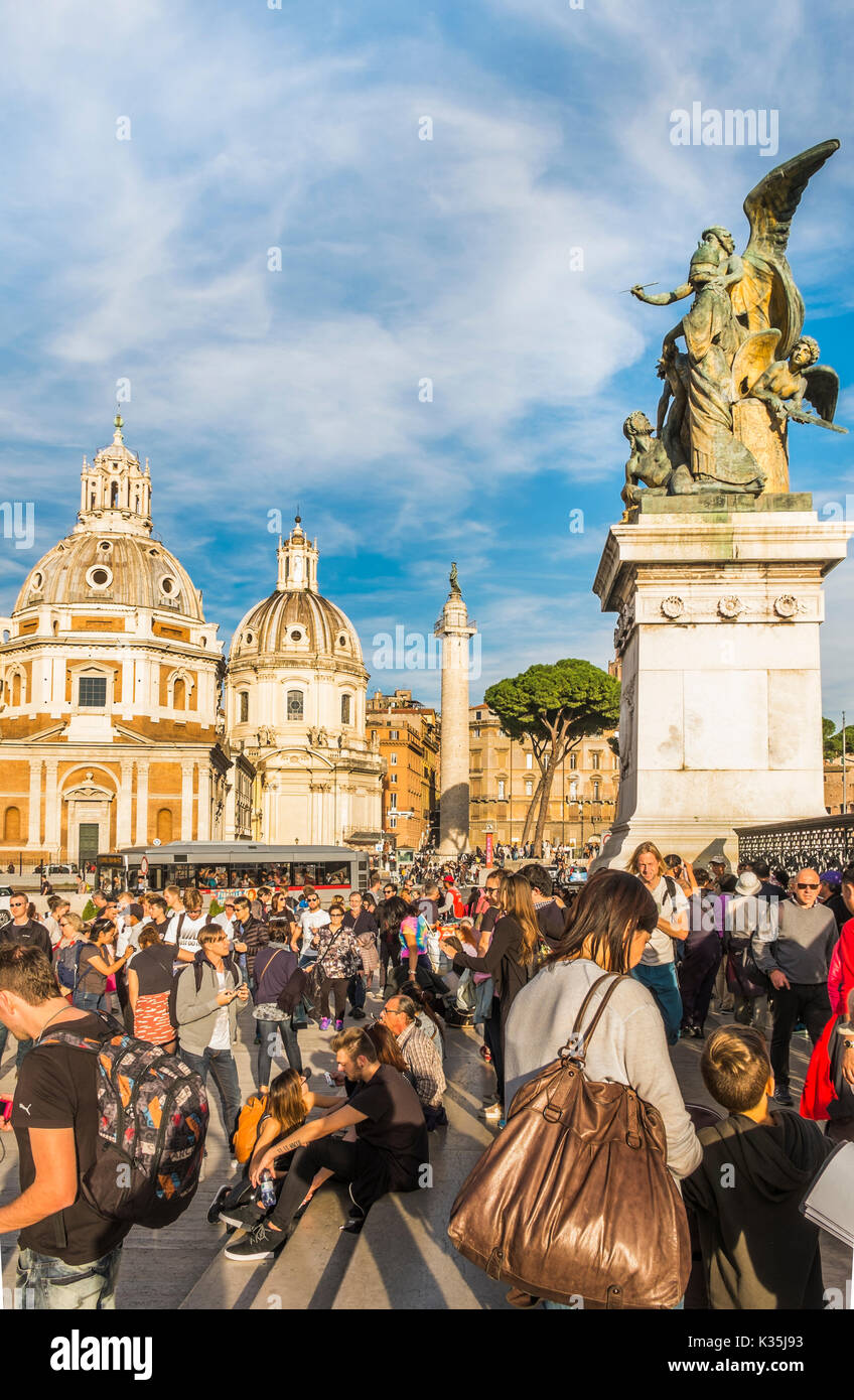 I turisti a piazza Venezia nella parte anteriore della scultura in bronzo all'entrata al monumento nazionale a Vittorio Emanuele II, Santa Maria di Loreto e San Foto Stock