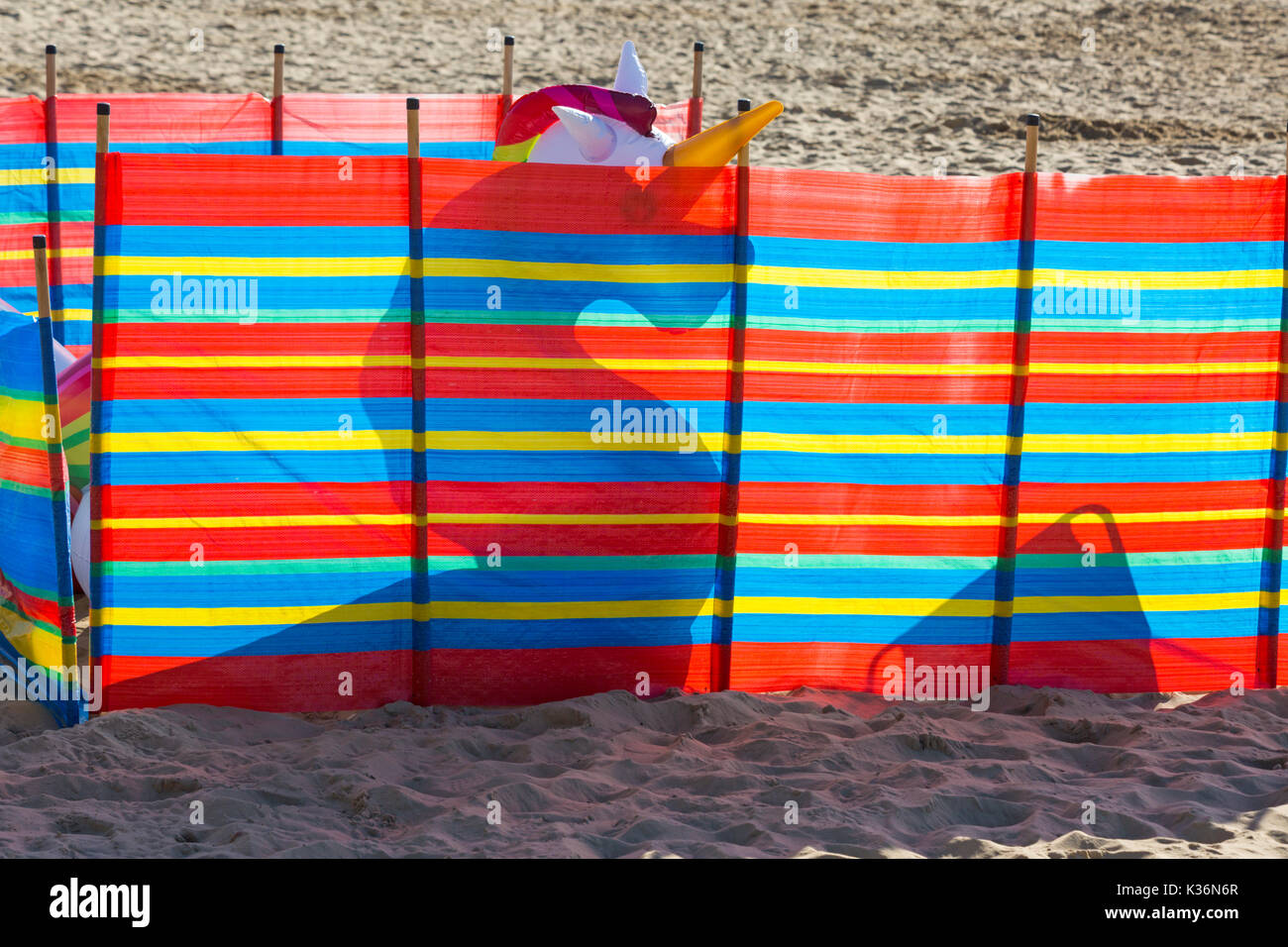 Bournemouth, Dorset, Regno Unito. 2 settembre 2017. Tempo nel Regno Unito: Bella calda giornata di sole a Bournemouth spiaggia come i visitatori arrivare presto per ottenere un buon posto il terzo giorno del Bournemouth Air Festival. Unicorno gonfiabile nascosto dietro windbreak. Credit: Carolyn Jenkins/Alamy Live News Foto Stock