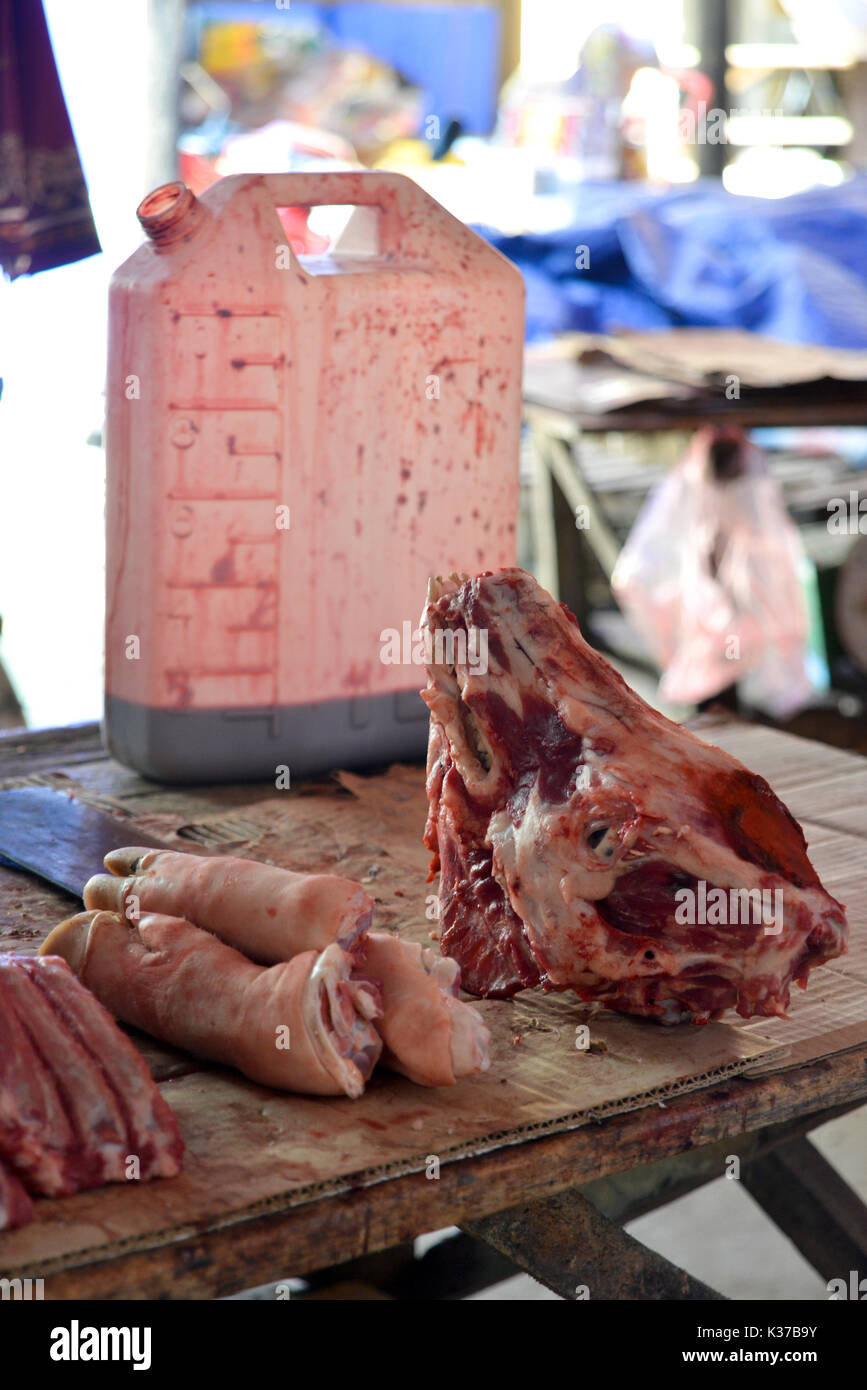 Un venditore di carne del macellaio, nel mercato giornaliero a Mai Chau, Vietnam, vendere le frattaglie, di suini di testa, zampetto e sangue. Foto Stock