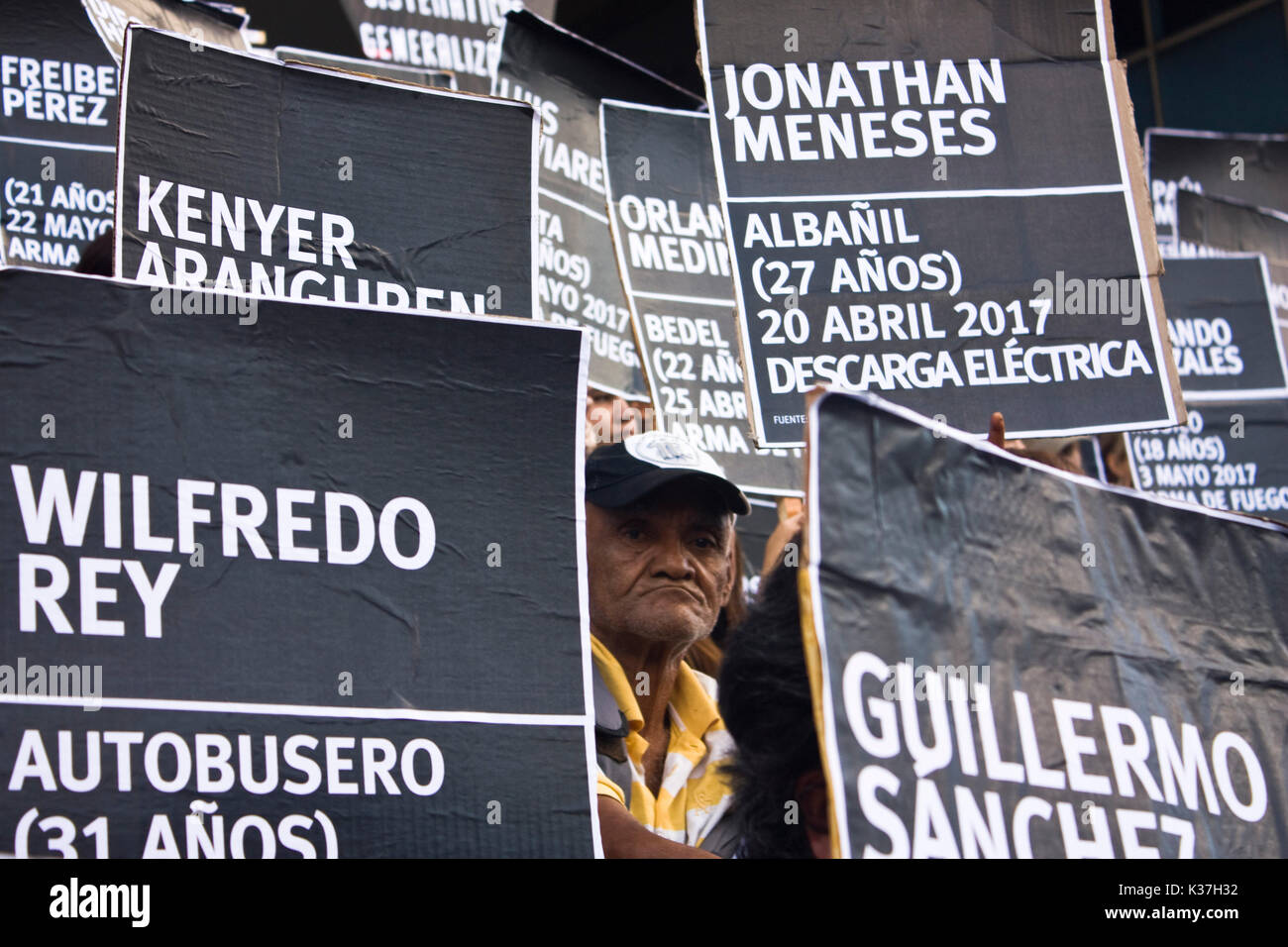 Un gruppo di manifestanti pacifici in attesa di cartoni con i nomi dei defunti manifestanti durante le proteste contro il governo di Nicolás Maduro. Foto Stock