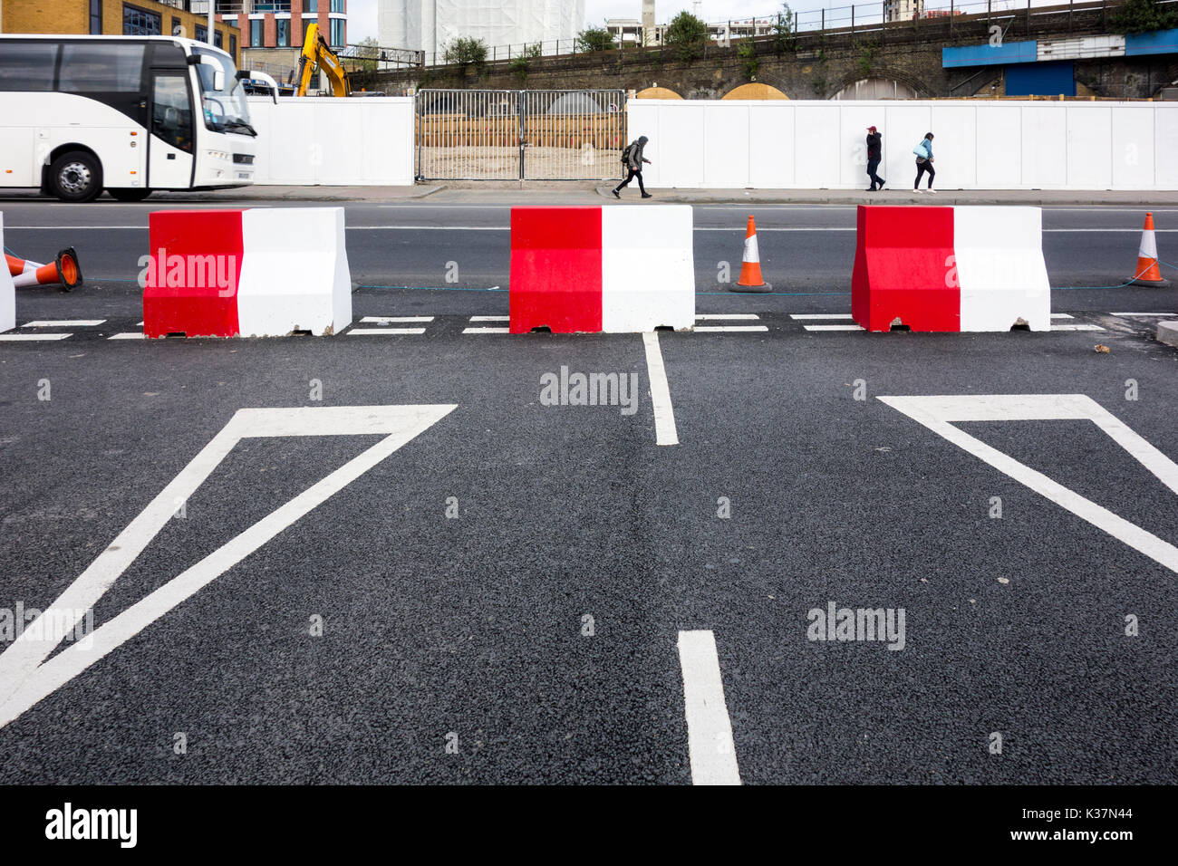 Il bianco e il rosso di blocchi in calcestruzzo su un nodo stradale bloccare una strada Foto Stock